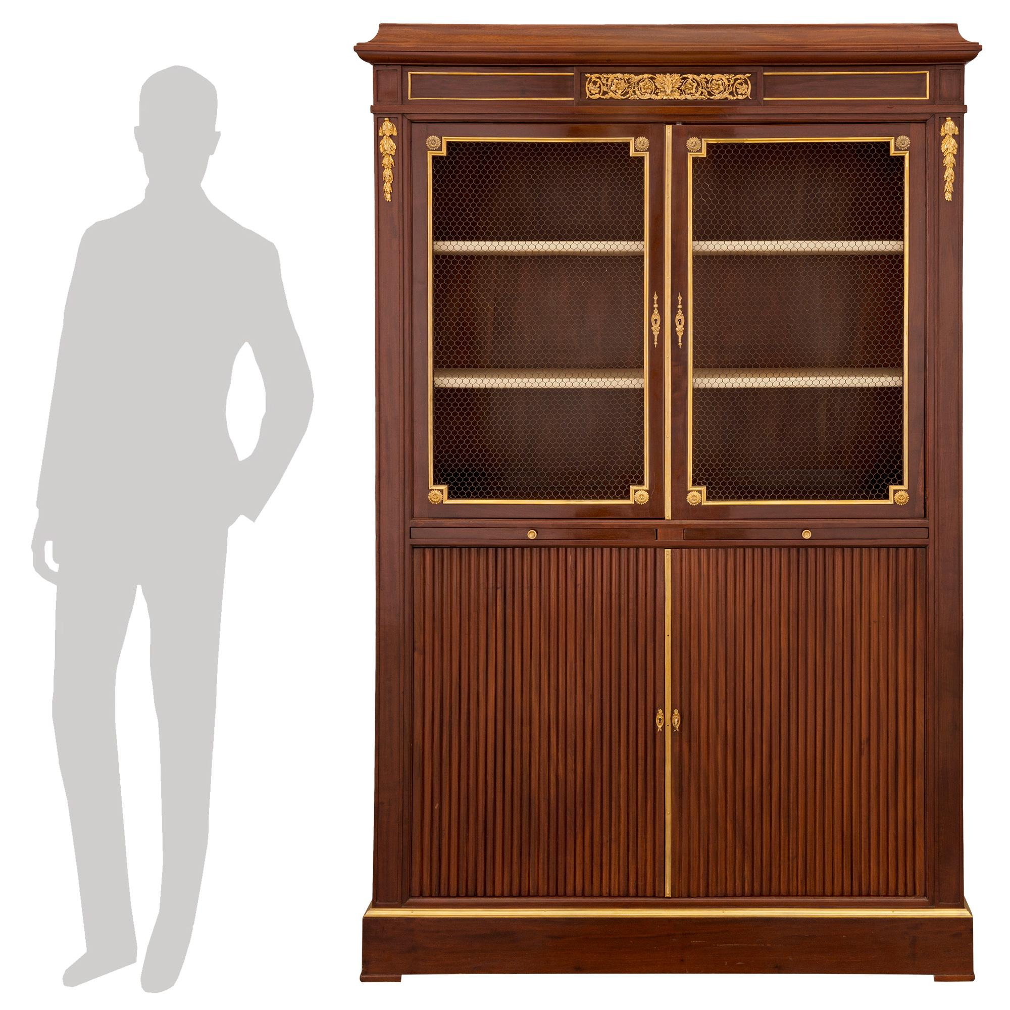 A handsome and high quality French 19th century Louis XVI st. mahogany and ormolu display cabinet, signed KRIEGER. The cabinet is raised by discreet elegant feet below the straight frieze. Above a fine mottled ormolu band are two doors with