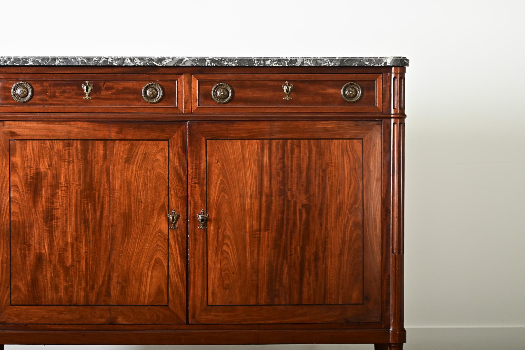 An extraordinary 19th century French mahogany and marble buffet, Louis XVI in style, to take pride of place nearly anywhere in the home. The slab of Saint Anne marble exhibits the signature ribbons of light gray veining over the black stone; shaped
