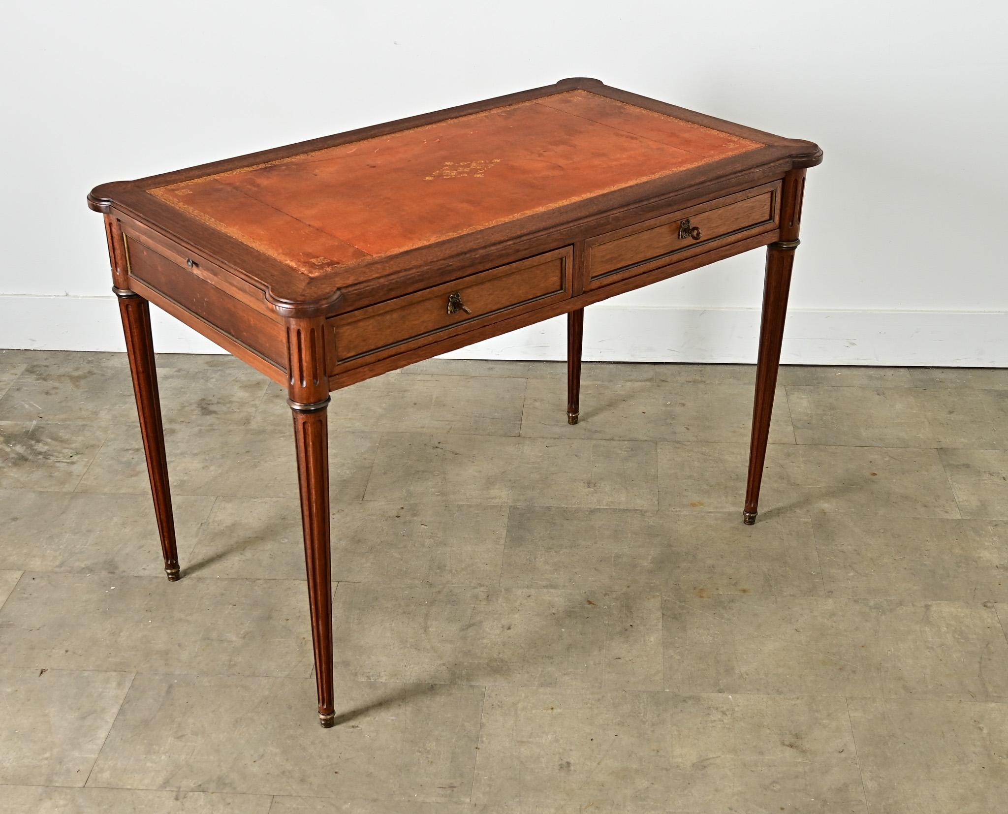 Ein französischer Mahagoni-Schreibtisch im Louis-XVI-Stil des 19. Jahrhunderts mit Lederbezug und versteckten Erweiterungen auf jeder Seite, um eine zusätzliche Ablagefläche zu schaffen, abgeschlossen mit abgeschrägten Ecken. Die Oberfläche hat eine