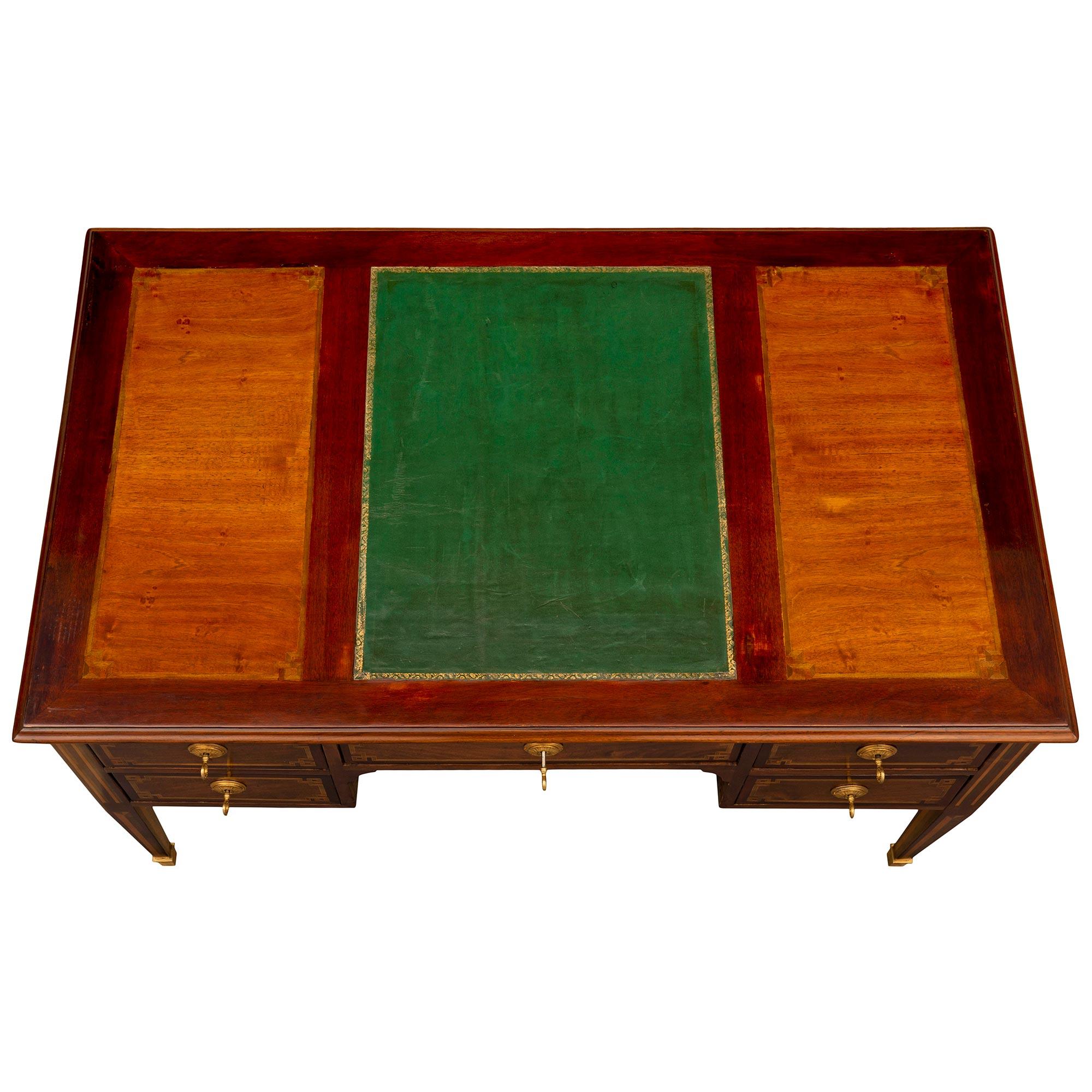 Ein schöner und eleganter französischer Louis-XVI-Schreibtisch aus dem 19. Jahrhundert aus Mahagoni, Tulipwood, Charmwood und Ormolu. Der Schreibtisch mit fünf Schubladen steht auf schlanken, sich verjüngenden Vierkantbeinen mit fein gearbeiteten