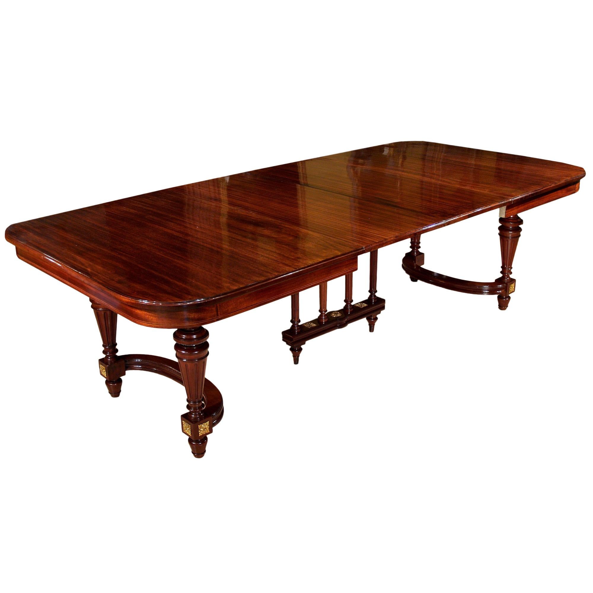 An exquisite French 19th century Louis XVI st. mahogany dining table with two extensions. The table is raised by Impressive circular fluted tapered legs with an 'h' stretcher. The stretcher is with three additional fluted columns. Each leg is