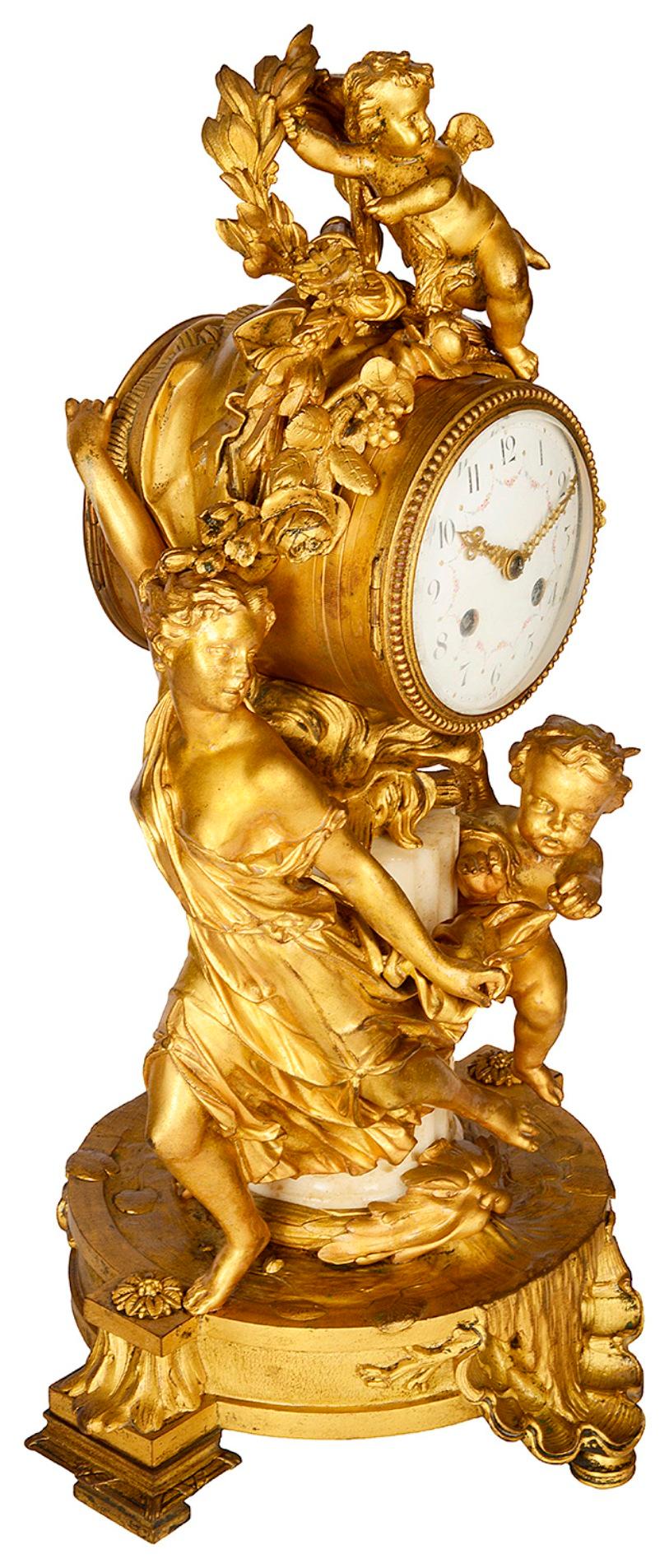 An enchanting late 19th century French gilded ormolu and marble mantel clock, depicting cherubs playing, one chasing a young girl, the other hiding amongst a wreath and foliage. The enamel clock face with an eight day duration, strikes on the hour