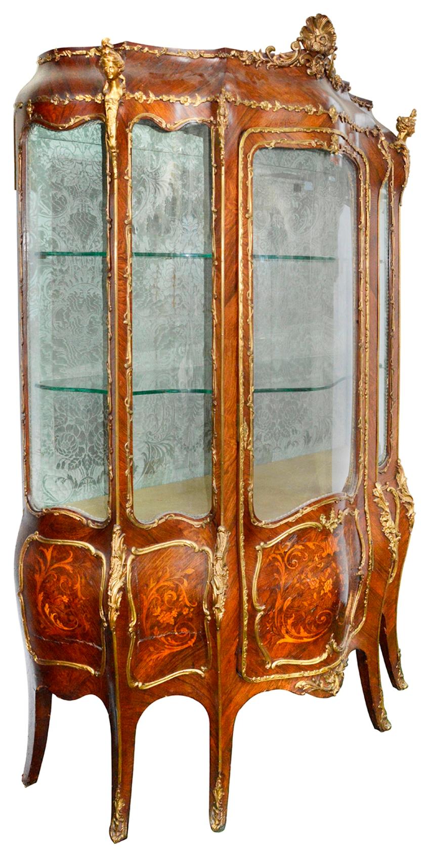 A good quality late 19th century French Marquetry inlaid bombe fronted Louis XVI style vitrine, having gilded ormolu monopodia mounts and mouldings. A single door opening to reveal glass shelves within, raised on our swept elegant legs.