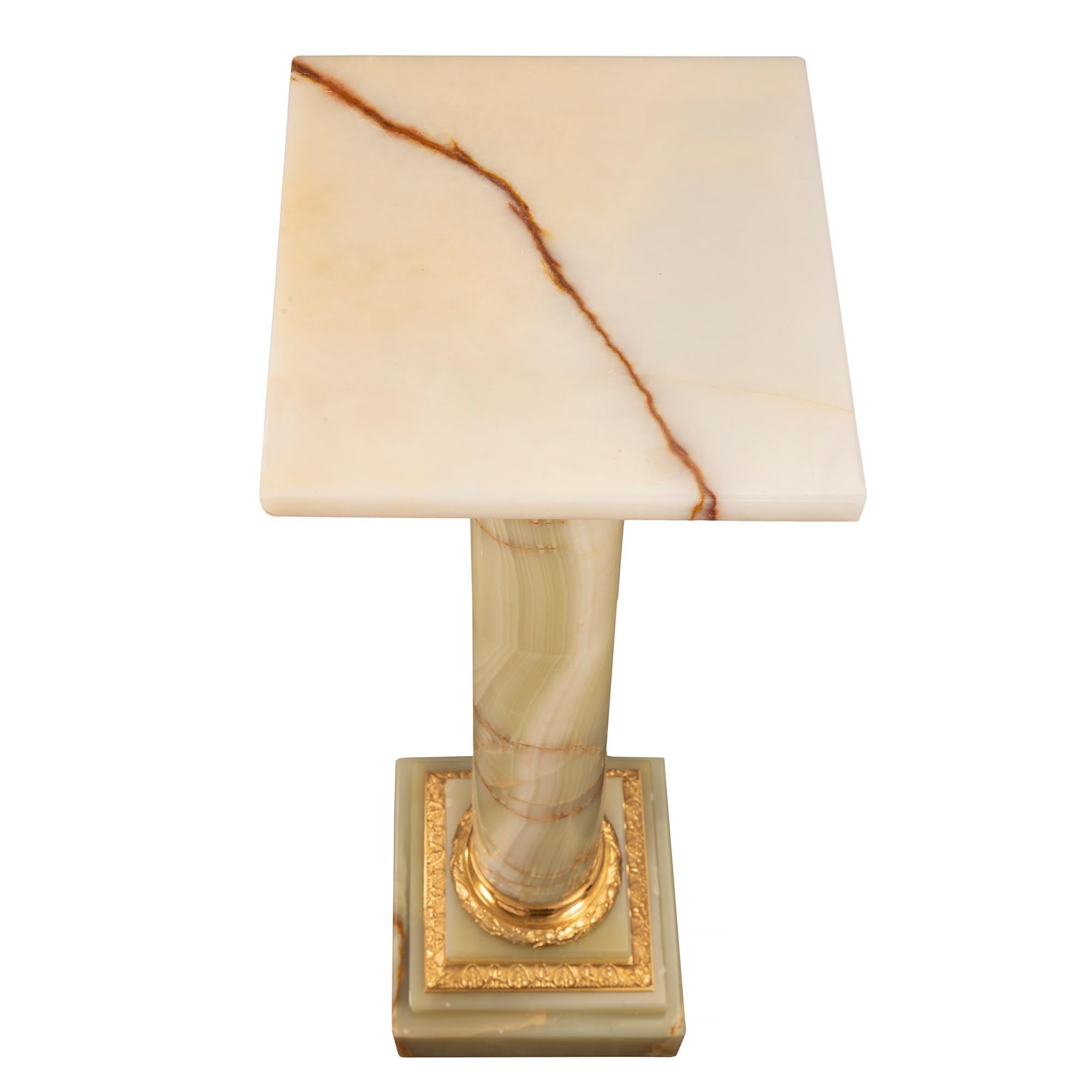 A striking and extremely elegant French 19th century Louis XVI st. onyx and ormolu pedestal column. The pedestal is raised by a square base with a stepped design and decorated with a fine wrap around foliate ormolu band. The ormolu socle displays a