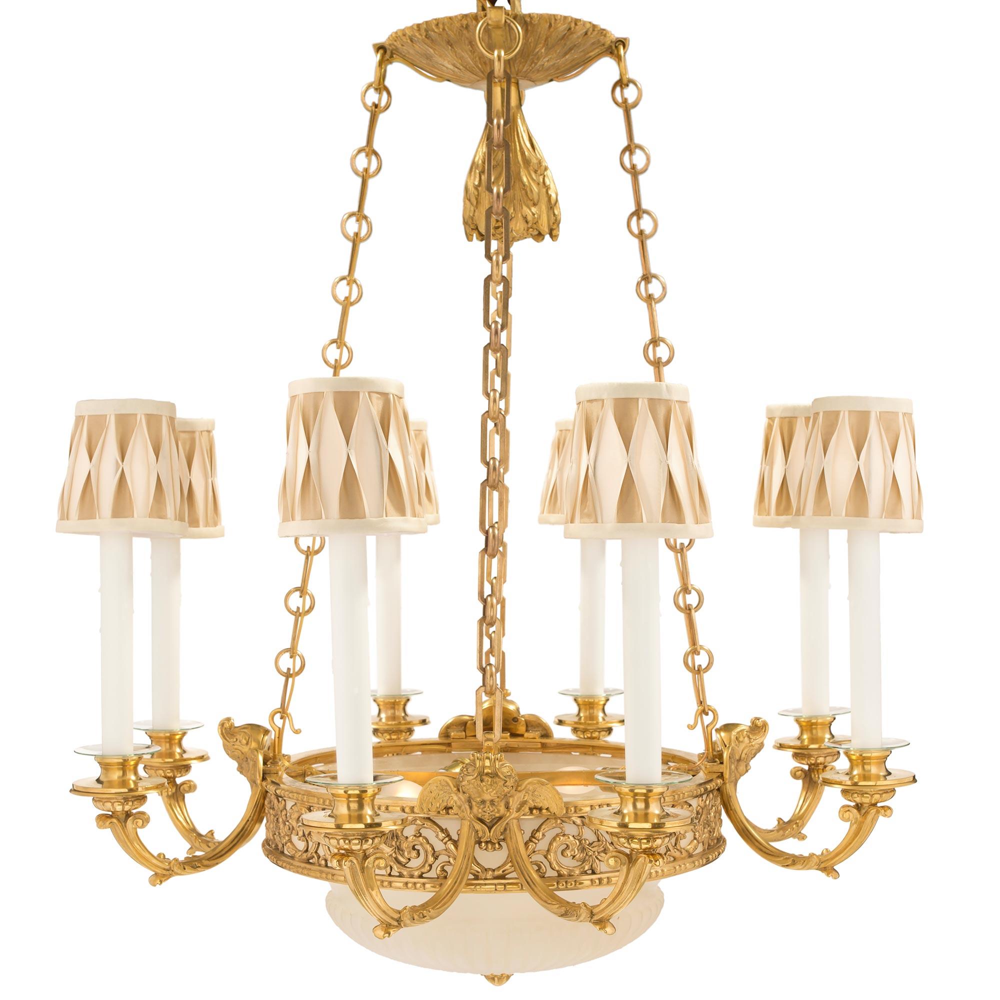 A most elegant French 19th century Louis XVI st. ormolu and alabaster twelve light chandelier. The chandelier has a bottom reeded cream colored alabaster dome with a central ormolu finial. The dome is held by a central band with foliate scrolls and
