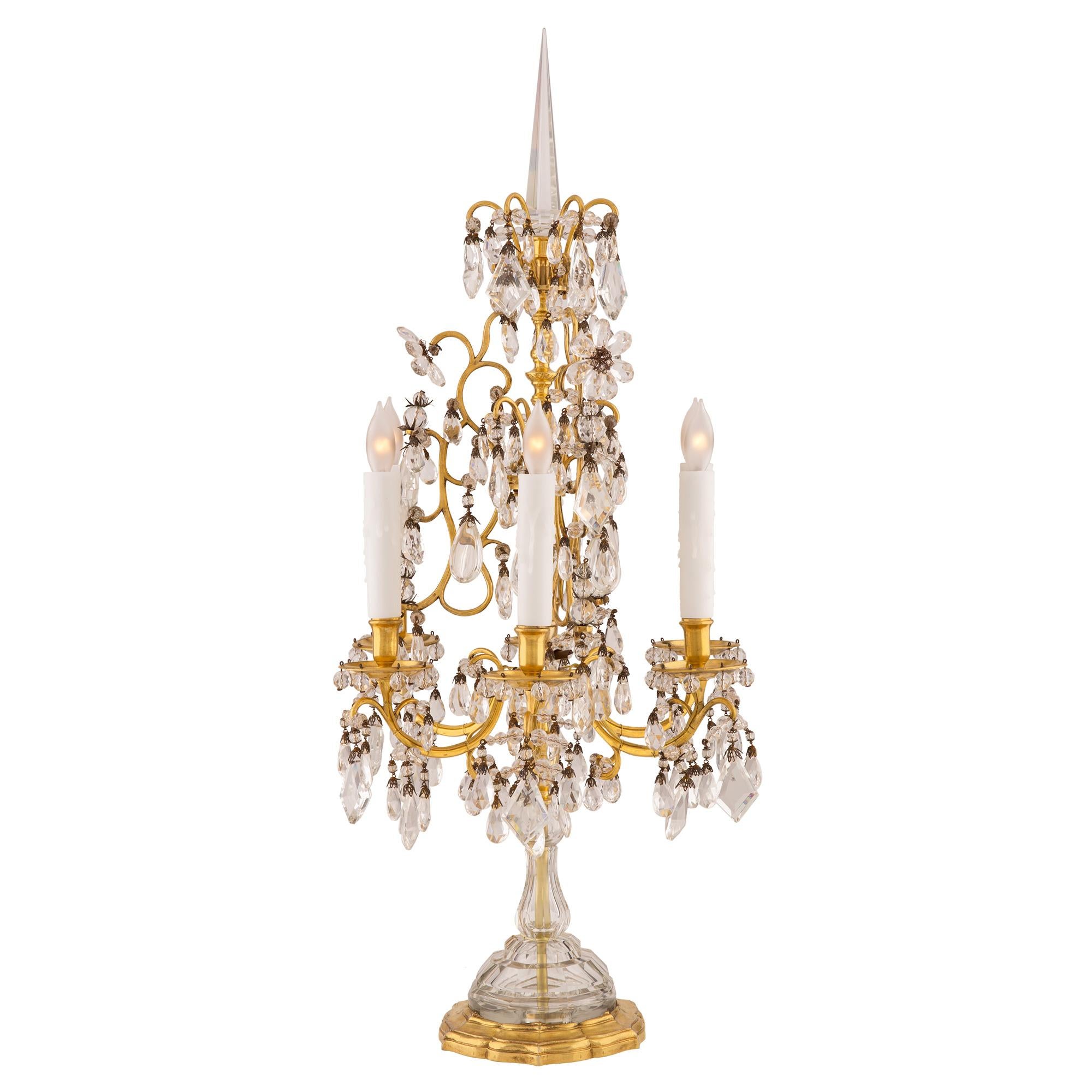 A remarkable and very high quality pair of French 19th century Louis XVI st. ormolu and Baccarat crystal Girandole lamps. Each Girandole is raised by a lovely scalloped shaped ormolu support with a Fine mottled design. The Baccarat crystal socle