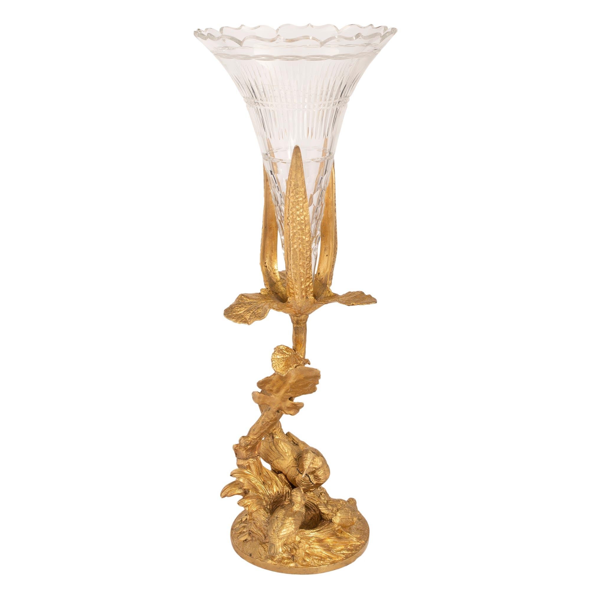 A beautiful and high quality French 19th century Louis XVI st. ormolu and Baccarat crystal vase. The vase is raised by a richly chased circular base, with charming birds in their nest, being fed by their mother. A branch extends upwards with finely
