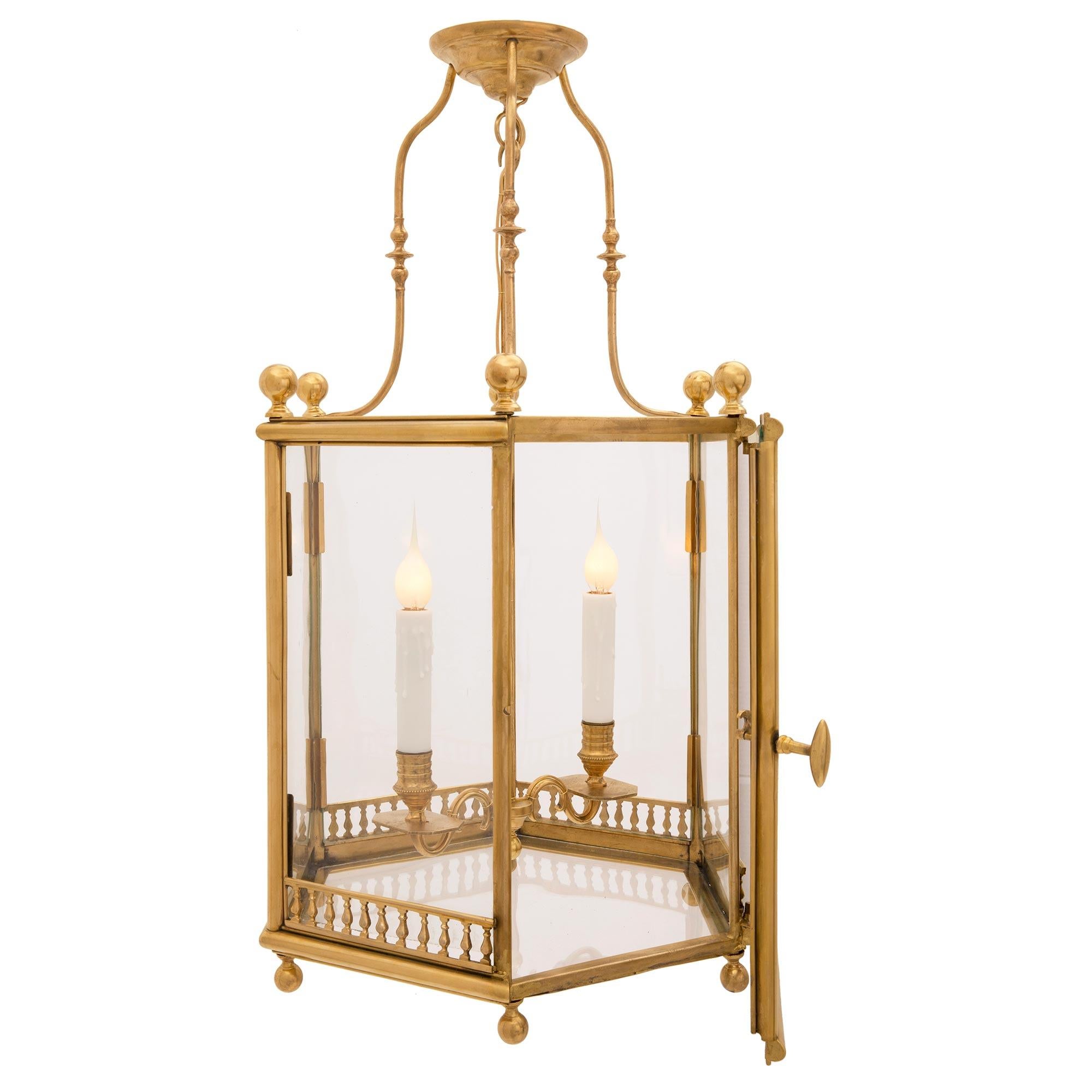 A charming and most decorative French 19th century Louis XVI st. ormolu and glass lantern. The hexagonal shaped lantern displays six fine bottom ball finials below an elegant mottled band. Each side retains their orignal glass panes above the lovely