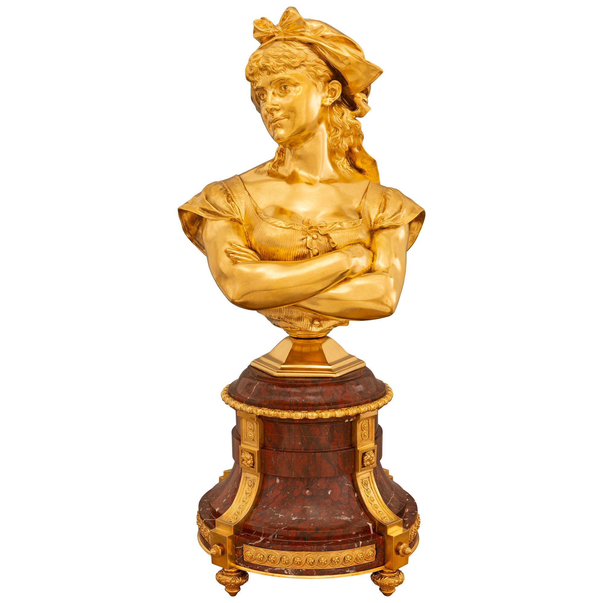 A stunning and high-quality French 19th century Louis XVI st. ormolu and Rouge Griotte marble bust, named Dorine and signed by Léopold Harzé. The bust is raised by an elegantly curved Rouge Griotte marble base with fine ormolu topie shaped feet.