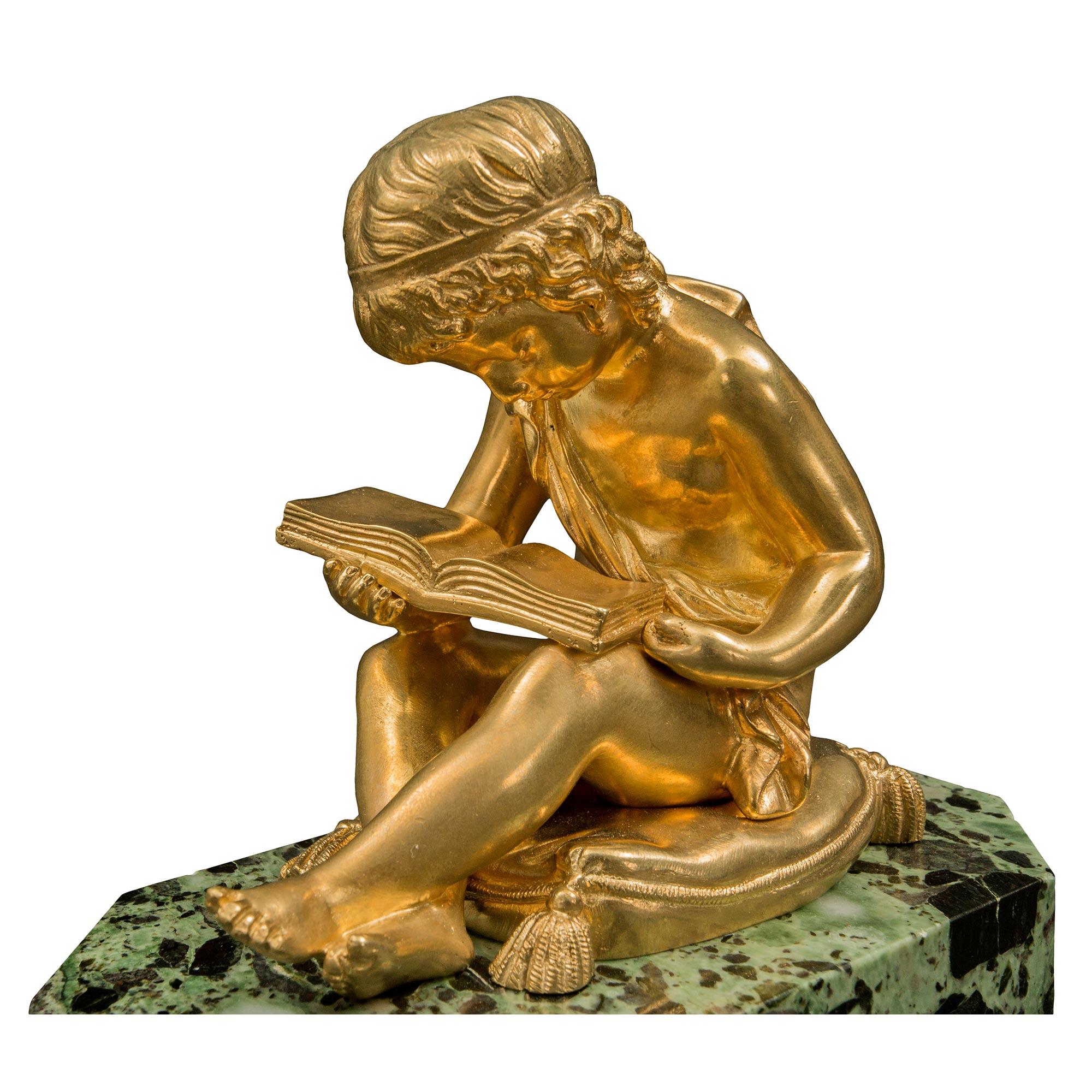 A most charming French 19th century Louis XVI st. ormolu and marble paper weight, signed and stamped. The decorative paper weight has a Vert Antique rectangular base with cut corners and a finely executed ormolu statue of a young boy. The boy is