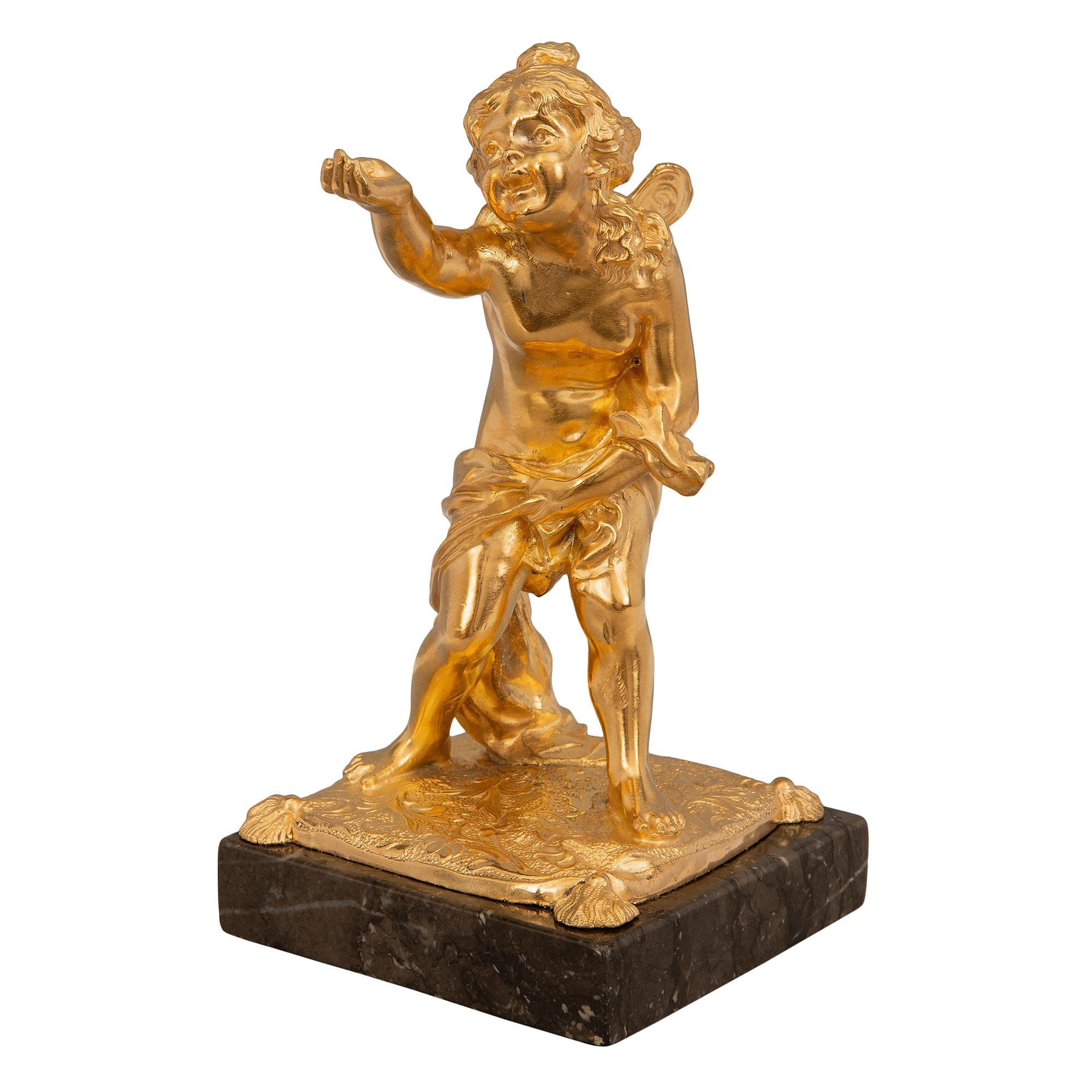 Un'affascinante statua in marmo e ormolu in scala ridotta del XIX secolo Luigi XVI. La statua è sollevata da una base quadrata in marmo sotto un raffinato disegno del terreno in ormolu. L'adorabile fanciulla alata è drappeggiata in un tessuto