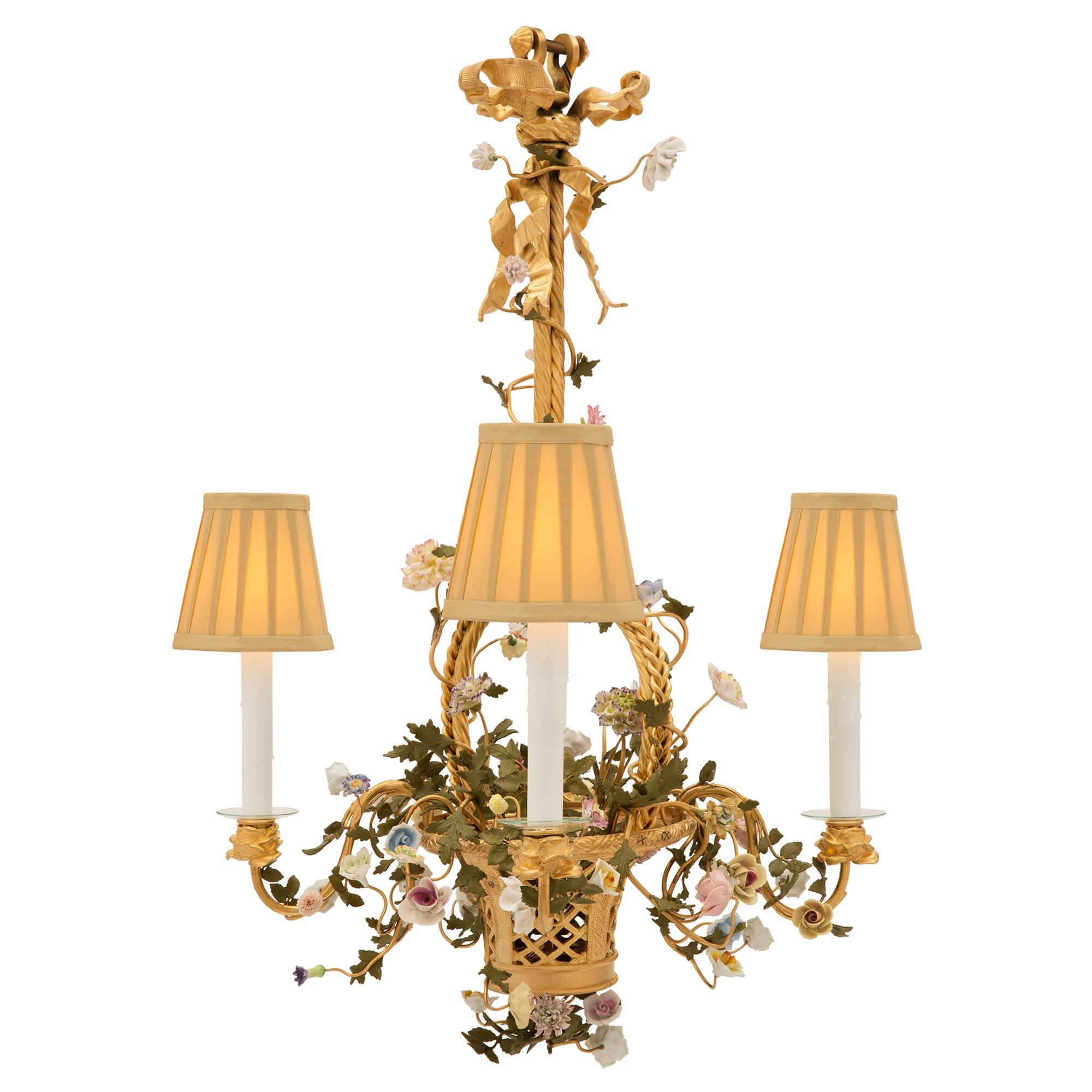 A beautiful and most unique French 19th century Louis XVI st. ormolu, Saxe porcelain and patinated metal four arm chandelier. The chandelier is centered by a charming and wonderfully executed woven ormolu basket from which beautiful and vividly