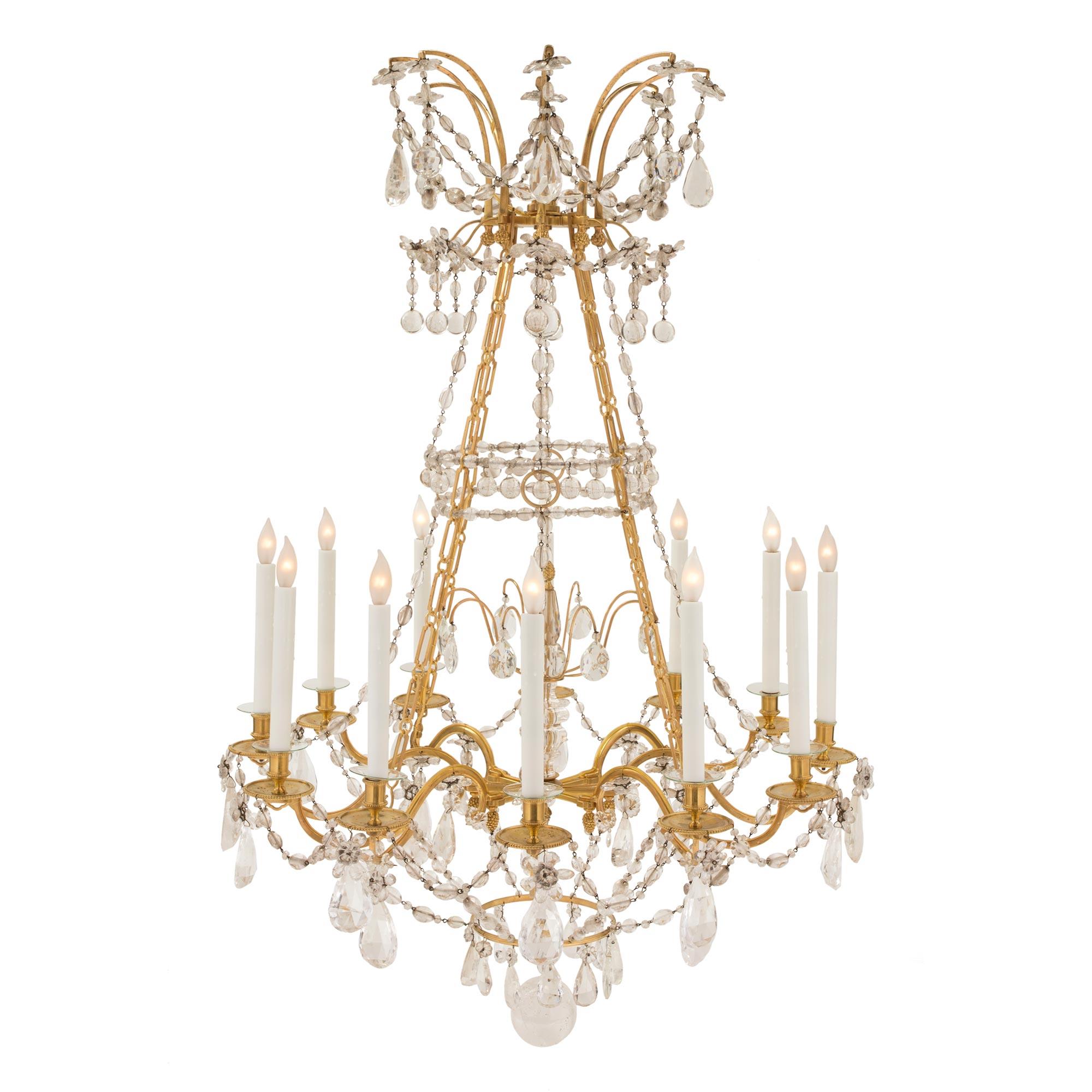 A stunning French mid 19th century Louis XVI st. ormolu, Baccarat crystal and rock crystal twelve arm chandelier. The chandelier is centered by a striking solid rock crystal bottom ball amidst beautifully cut Baccarat crystal pendants. Above the