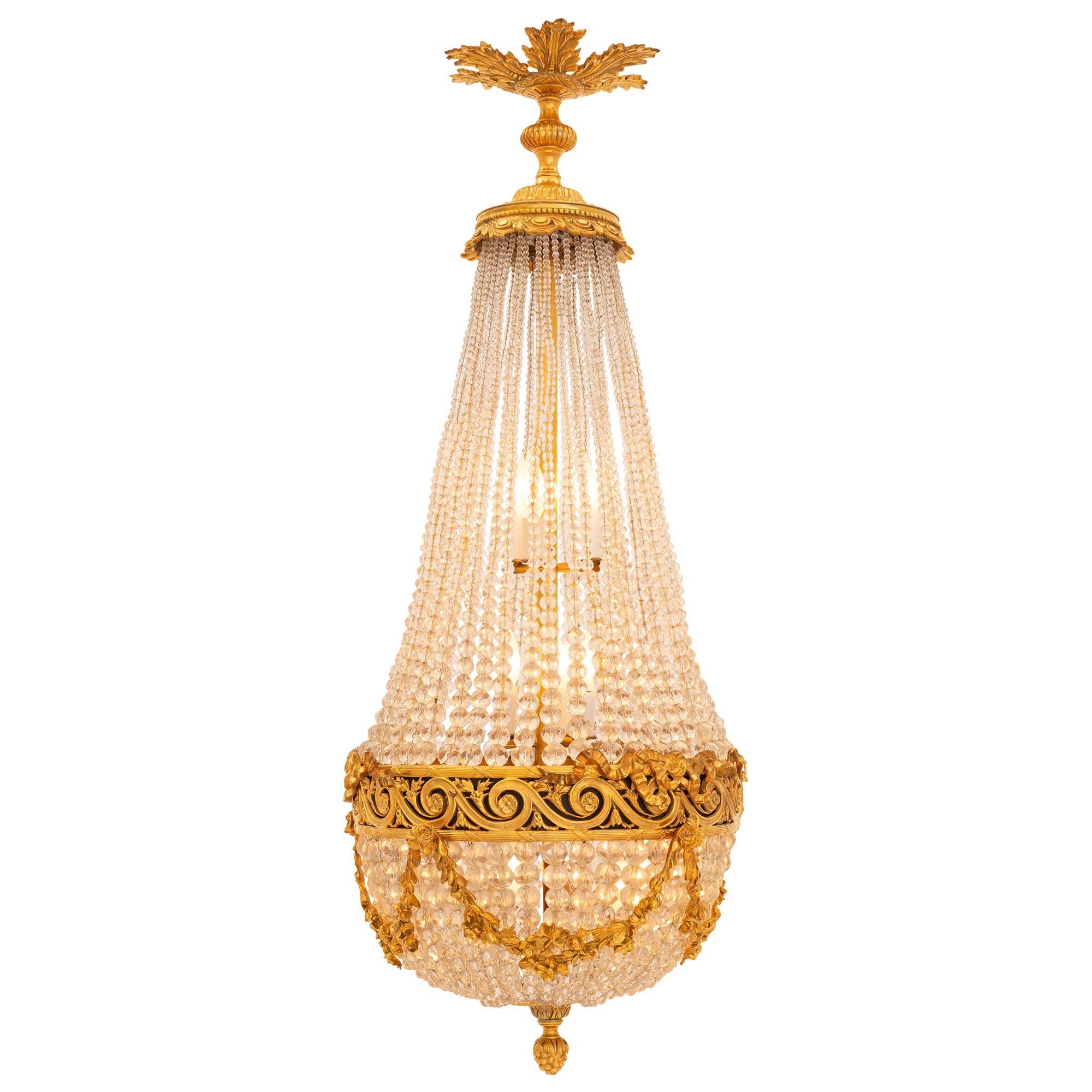 A beautiful and high quality French 19th century Louis XVI st. ormolu, patinated bronze, and crystal chandelier. The eleven light montgolfier shaped chandelier is centered by a richly chased bottom berried foliate finial below a fine circular
