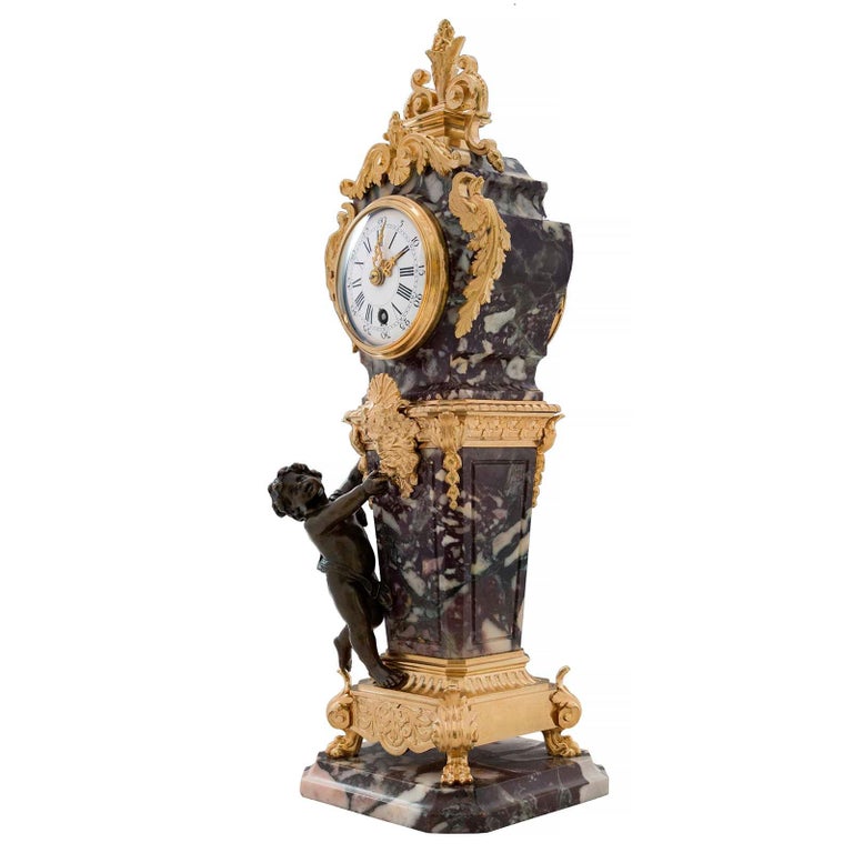 An exceptional French 19th century Louis XVI st. ormolu, patinated bronze and Brèche Violette marble clock. The clock is raised by a square marble base with cut corners and a mottled border. The central ormolu support is raised by handsome paw feet