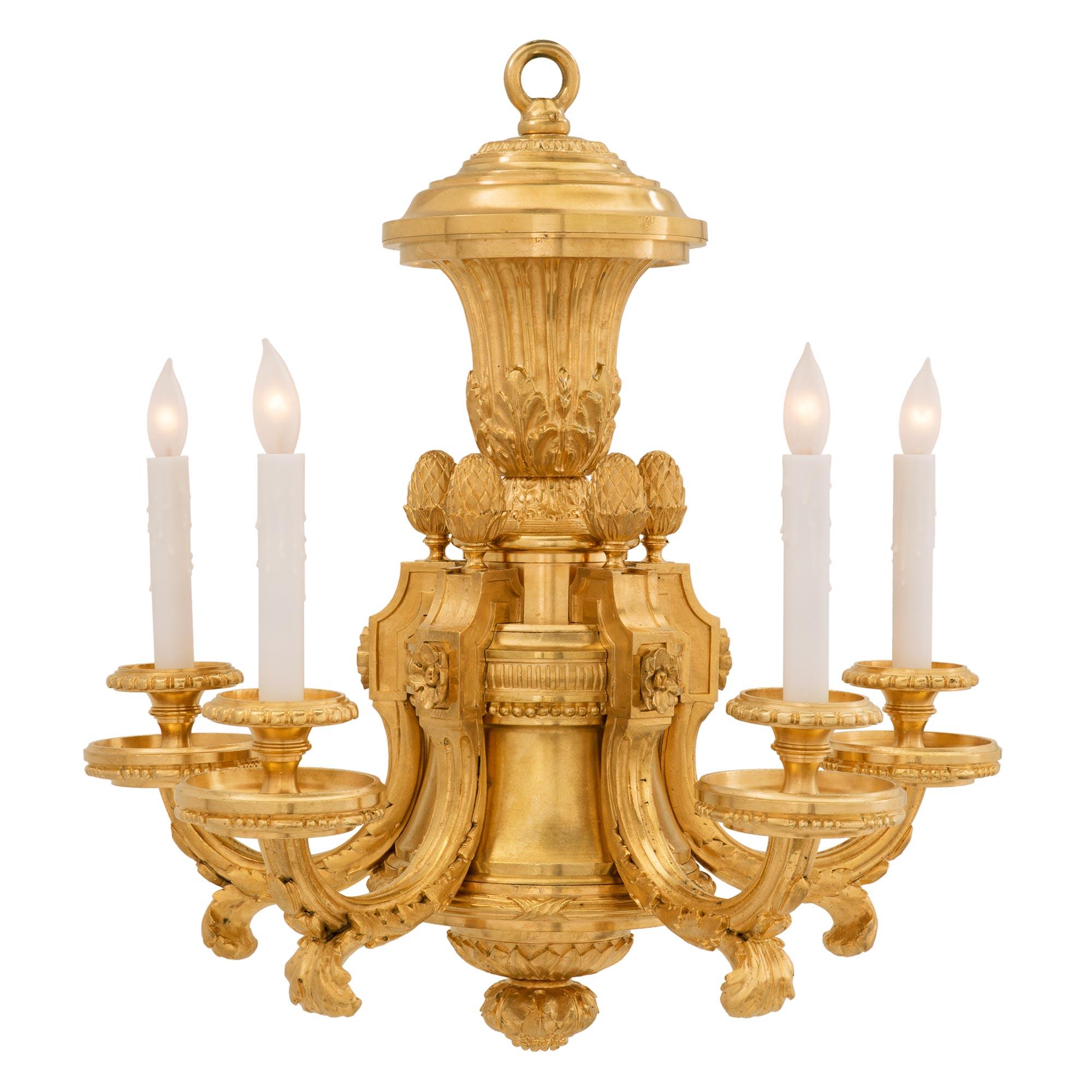 An exceptional French 19th century Louis XVI st. ormolu five arm chandelier. The chandelier is centered by a charming and richly chased bottom floral finial below fine palmettes and tied wrap around bands. Each of the five arms are adorned with