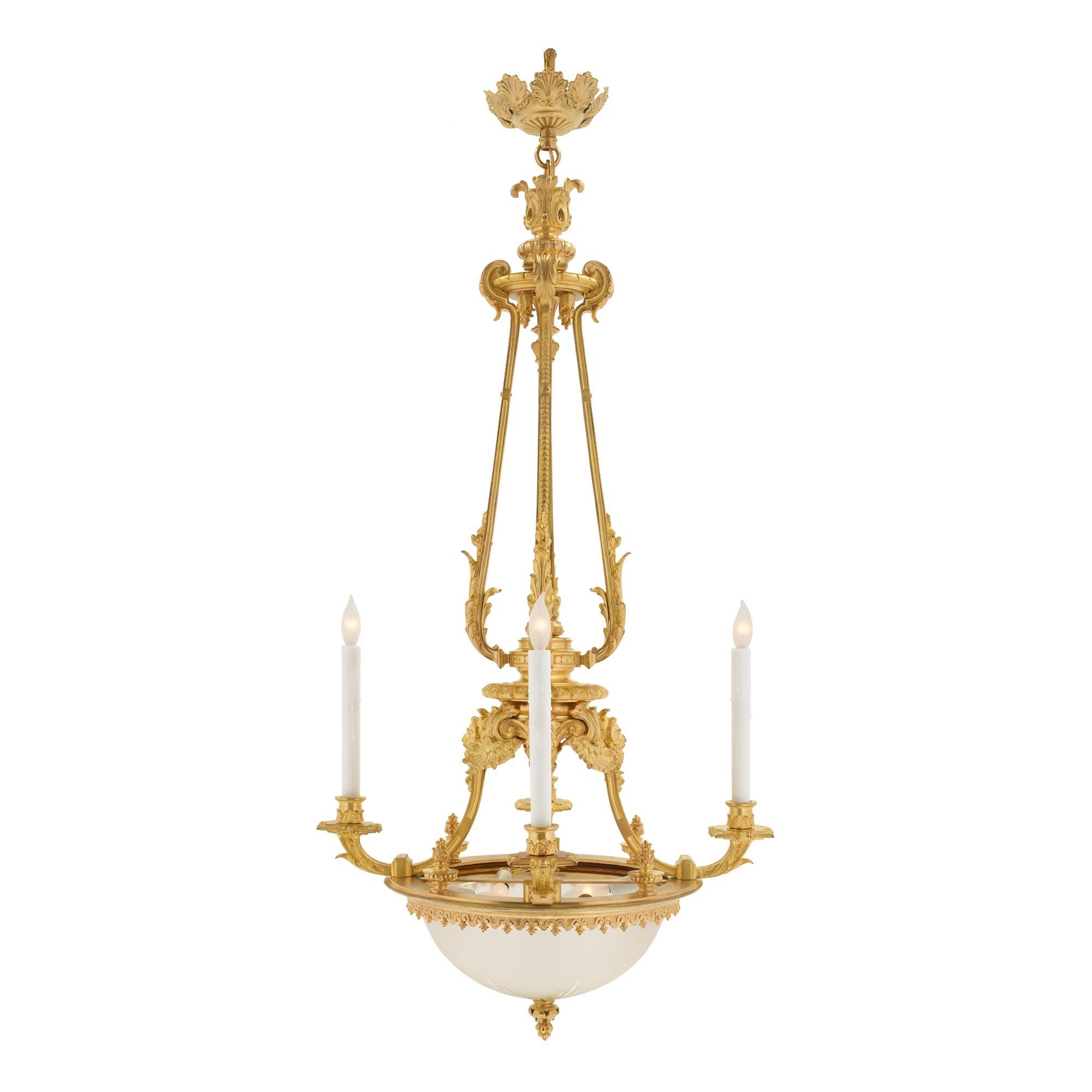 A stunning and most elegant French 19th century Louis XVI st. ormolu four arm, eight light chandelier. The chandelier is centered by a fine ormolu foliate finial below the original stunning and most decorative etched and cut glass bowl which is