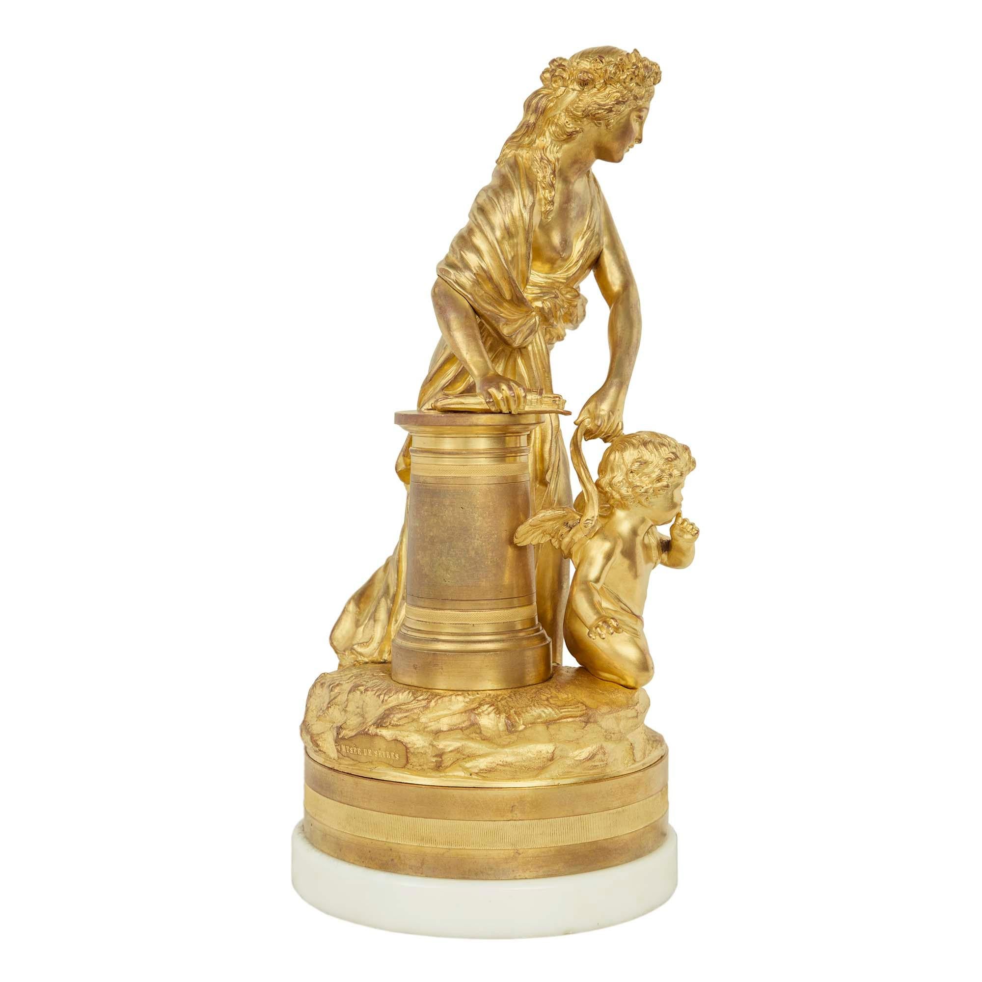 A high quality and most charming French 19th century Louis XVI st. ormolu statue of a maiden with winged cherub signed Musée de Sèvres. The statue is raised by a circular white Carrara marble base below the ormolu support with a wrap around reeded