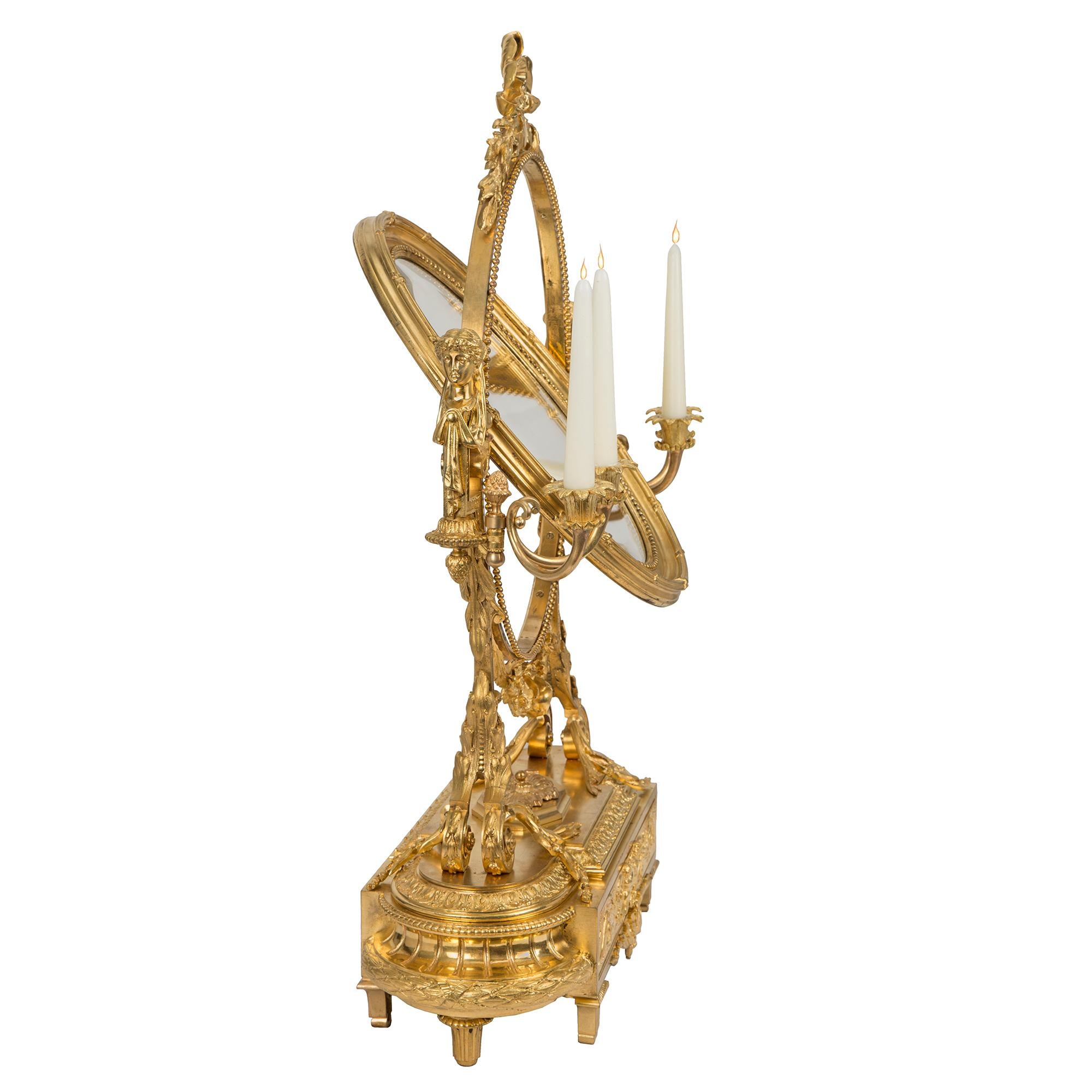 Un impressionnant et élégant miroir de courtoisie en bronze doré de style Louis XVI du 19ème siècle signé Susse Frères à Paris. Les pieds fuselés reposent sur une base avec un tiroir central richement ciselé, décoré de chérubins détaillés au milieu