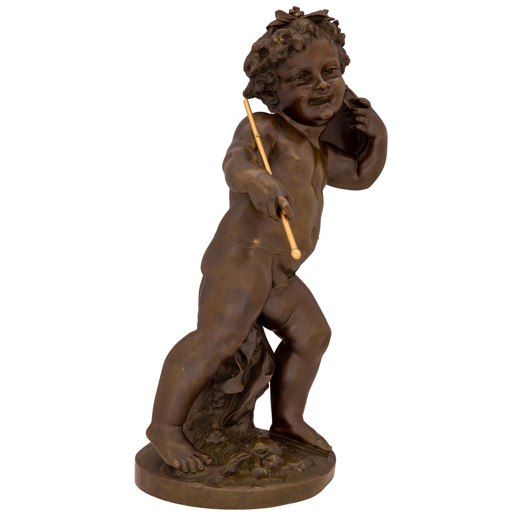 A charming and high quality French 19th century Louis XVI st. patinated bronze and ormolu statue, signed 'Rougelet'. The statue is raised by a circular base with a wonderfully executed ground like design and a tree truck. The whimsical and richly