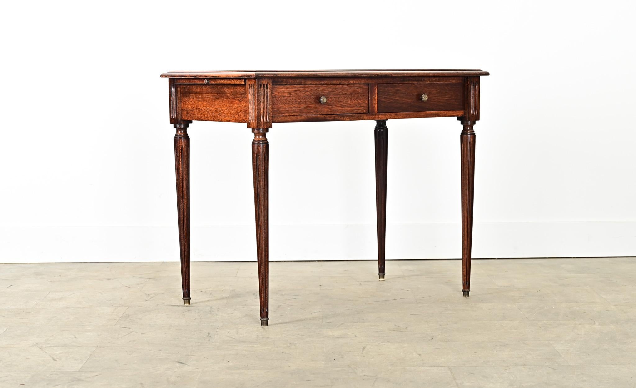 An ingenious leather-topped mahogany writing desk with hidden extensions on each side to add occasional surface area. The leaves on the sides are a matcha green leather framed by gold tooling, whereas the cognac tone of the top surface is mottled in
