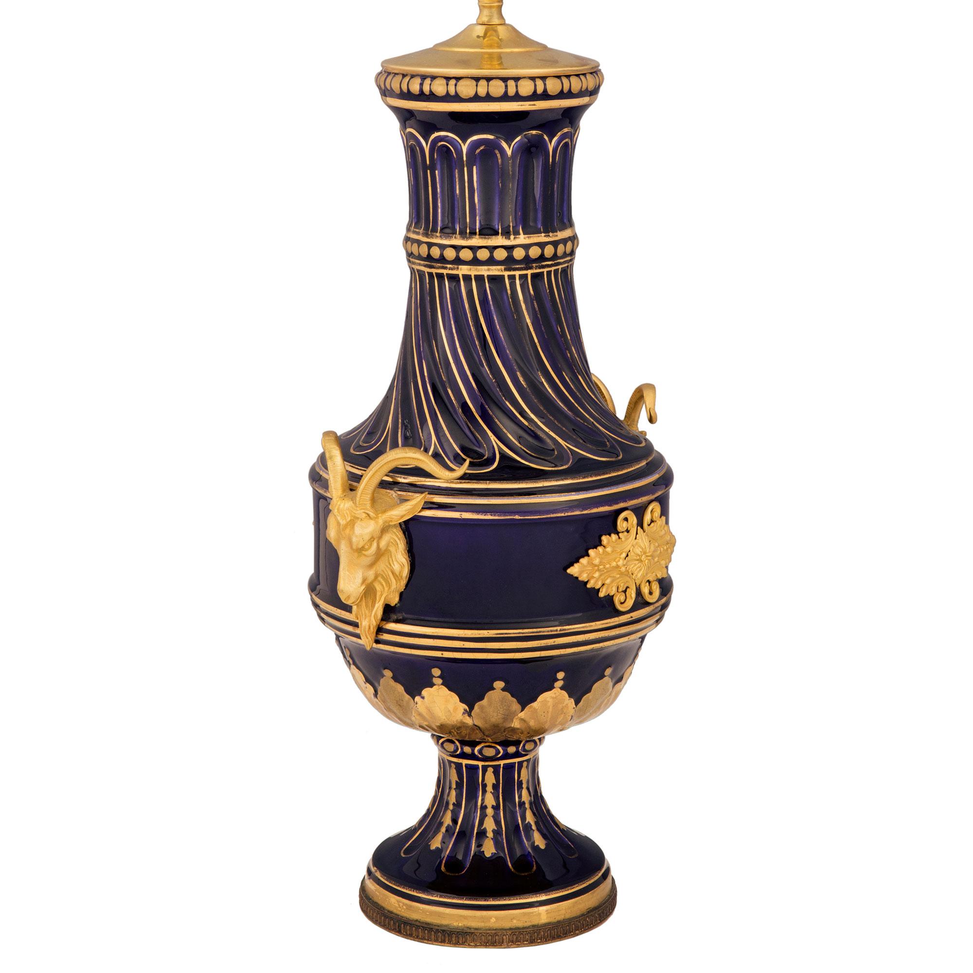 A fabulous French 19th century Louis XVI st. cobalt blue Sèvres porcelain, gilt and ormolu lamp. The lamp is raised by a fine circular base with a bottom ormolu band and fine foliate gilt accents at the fluted socle support. The elegantly shaped