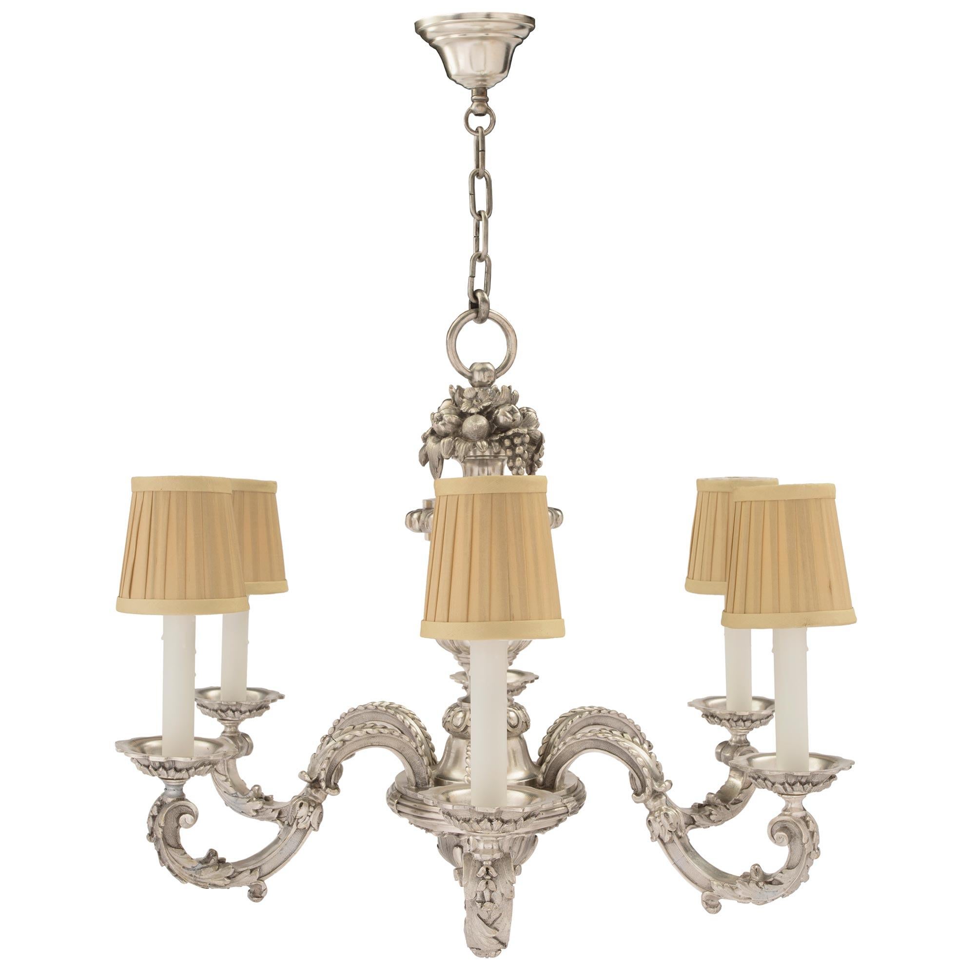 A lovely French 19th century Louis XVI st. silvered bronze six arm chandelier. The chandelier is centered by a finely detailed bottom acorn finial and a beautiful foliate pattern. The six S scrolled arms are adorned with large richly chased acanthus