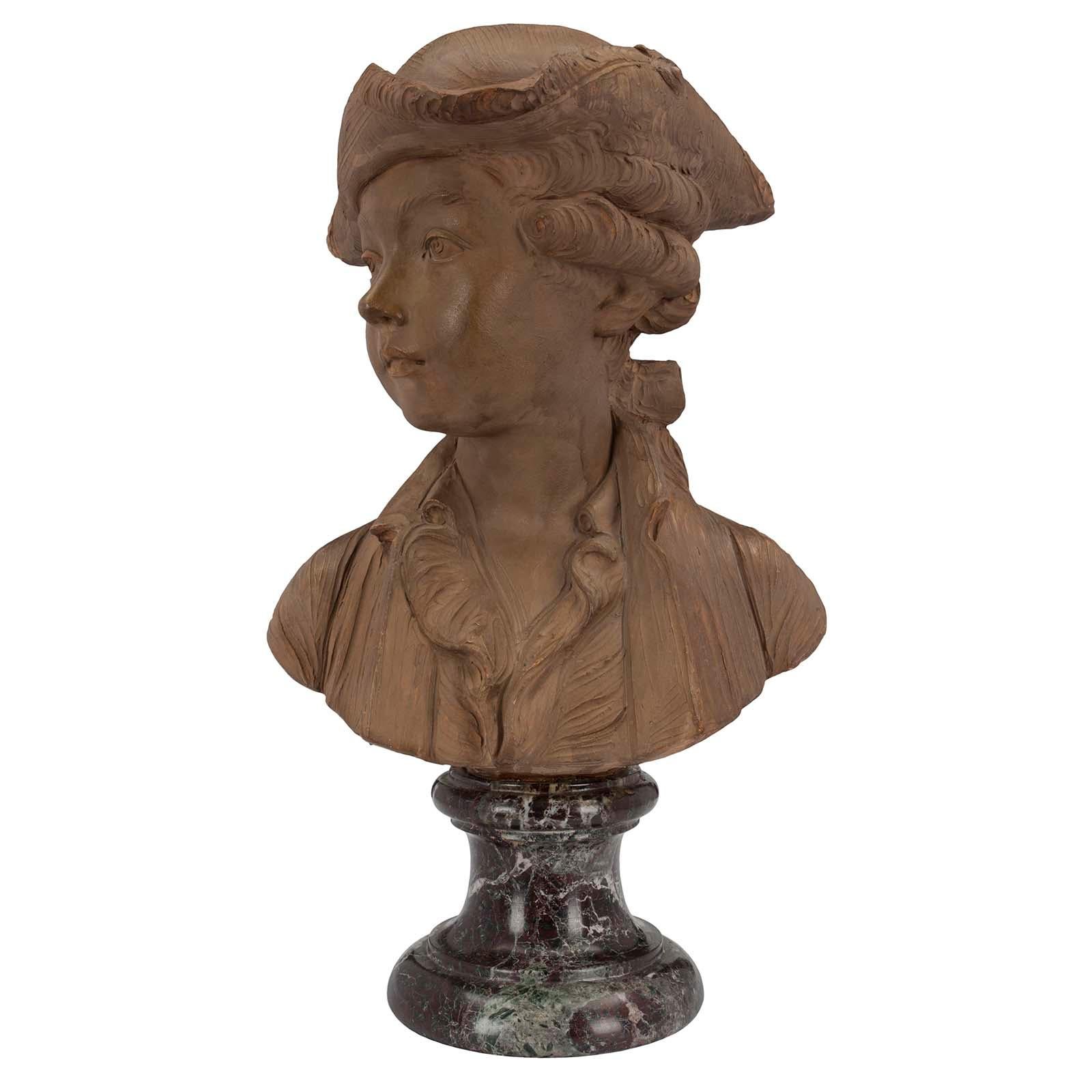 A charming and most decorative French 19th century Louis XVI style terracotta bust of a young boy signed Houdon. The terra cotta bust is raised by an attractive Rosso Levanto circular mottled marble base. Above is the elegant bust of a young boy