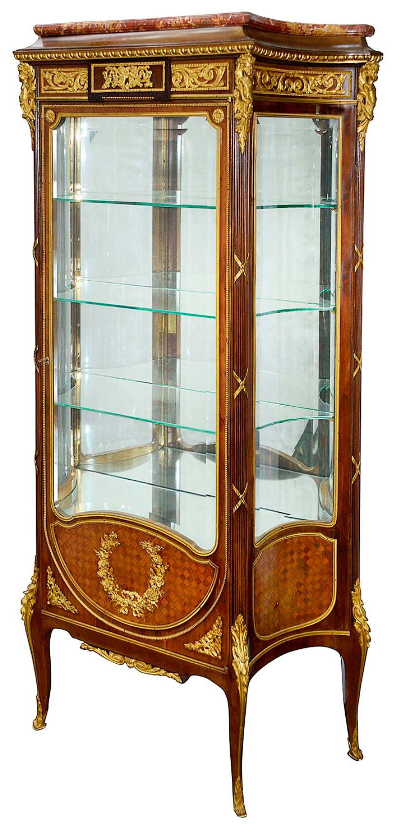 A very good quality late 19th century French gilded ormolu mounted, marble topped vitrine. Having wonderful quality cherub mounts to the corners, scrolling folaite decoration, reeded columns, the glazed door opening to reveal adjustable glass