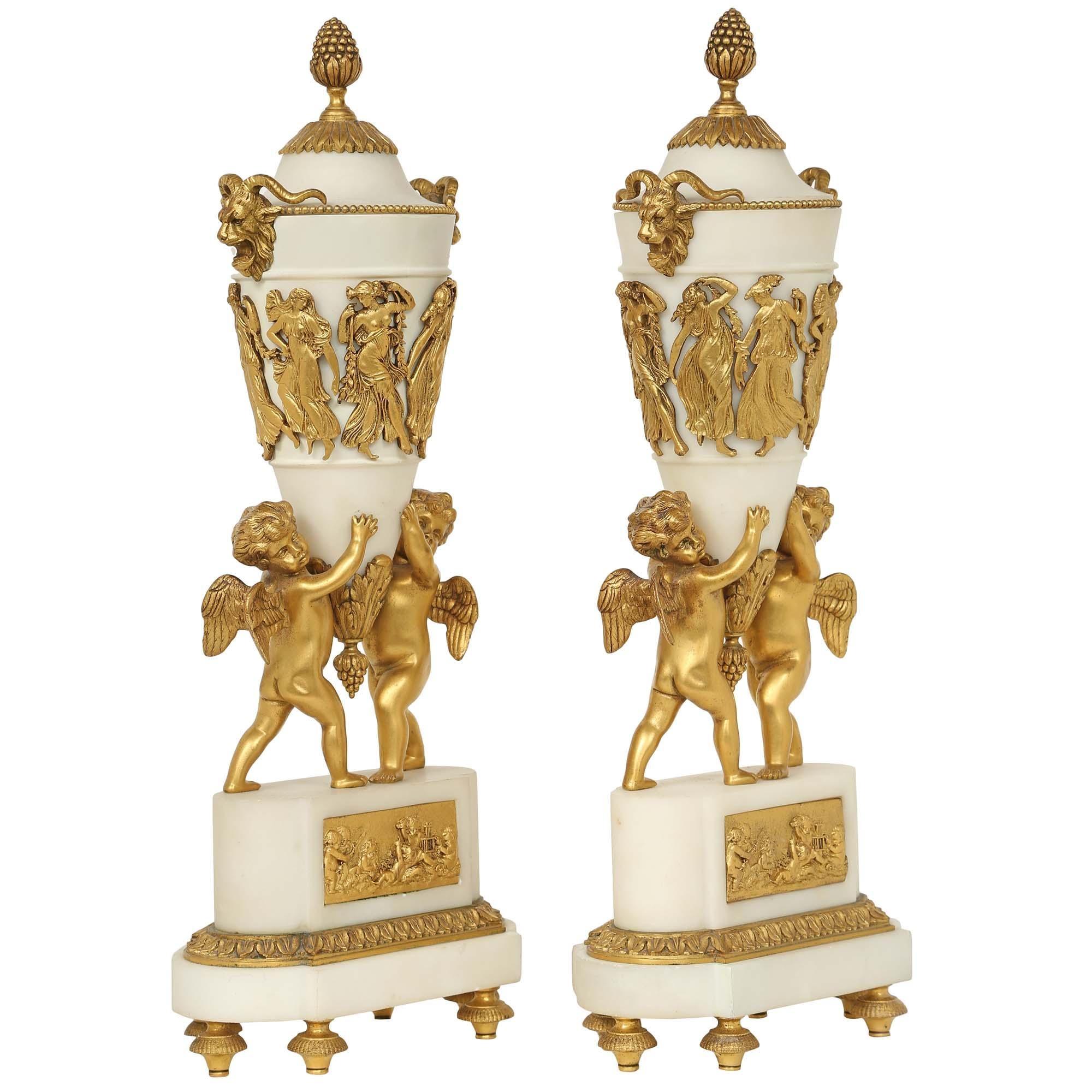 An exceptional pair of mid 19th century French Louis XVI st. white Carrara marble and ormolu mounted cassolettes. The pair are raised by a marble base above topie shaped ormolu supports. The front of the base is decorated by an ormolu plaque,