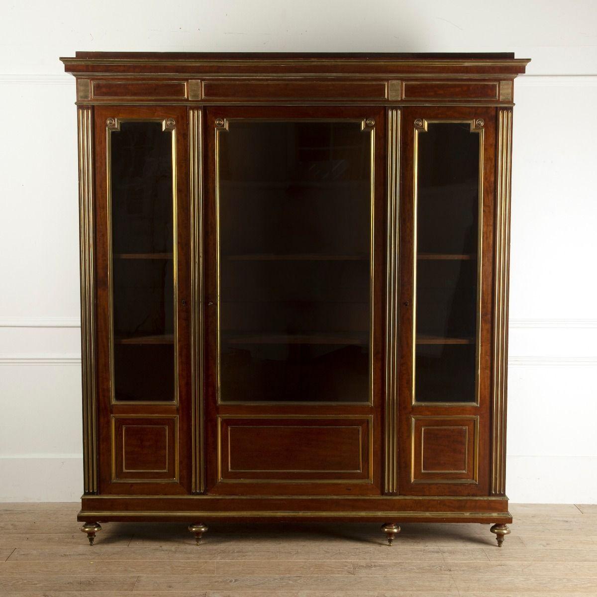 Superb quality French three door bookcase.
The figured mahogany is surrounded by polished brass mounts and mouldings, with fluted supports.
The glazed doors have stylish re-entrant corners finished with roundels. Wonderful geometric style