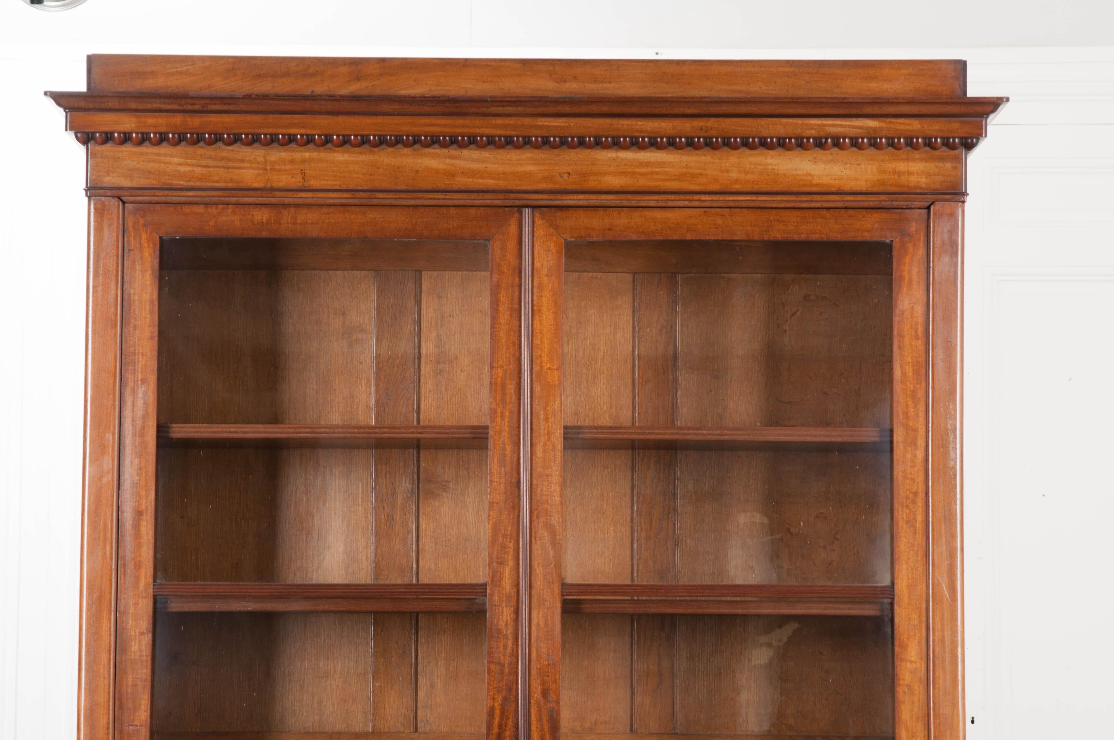 A handsome French bibliothèque, made of mahogany, from the latter part of the 19th century. The bookcase has two glass front doors, which can be locked, that close before the antique’s interior. The bibliothèque has one key. The doors have large