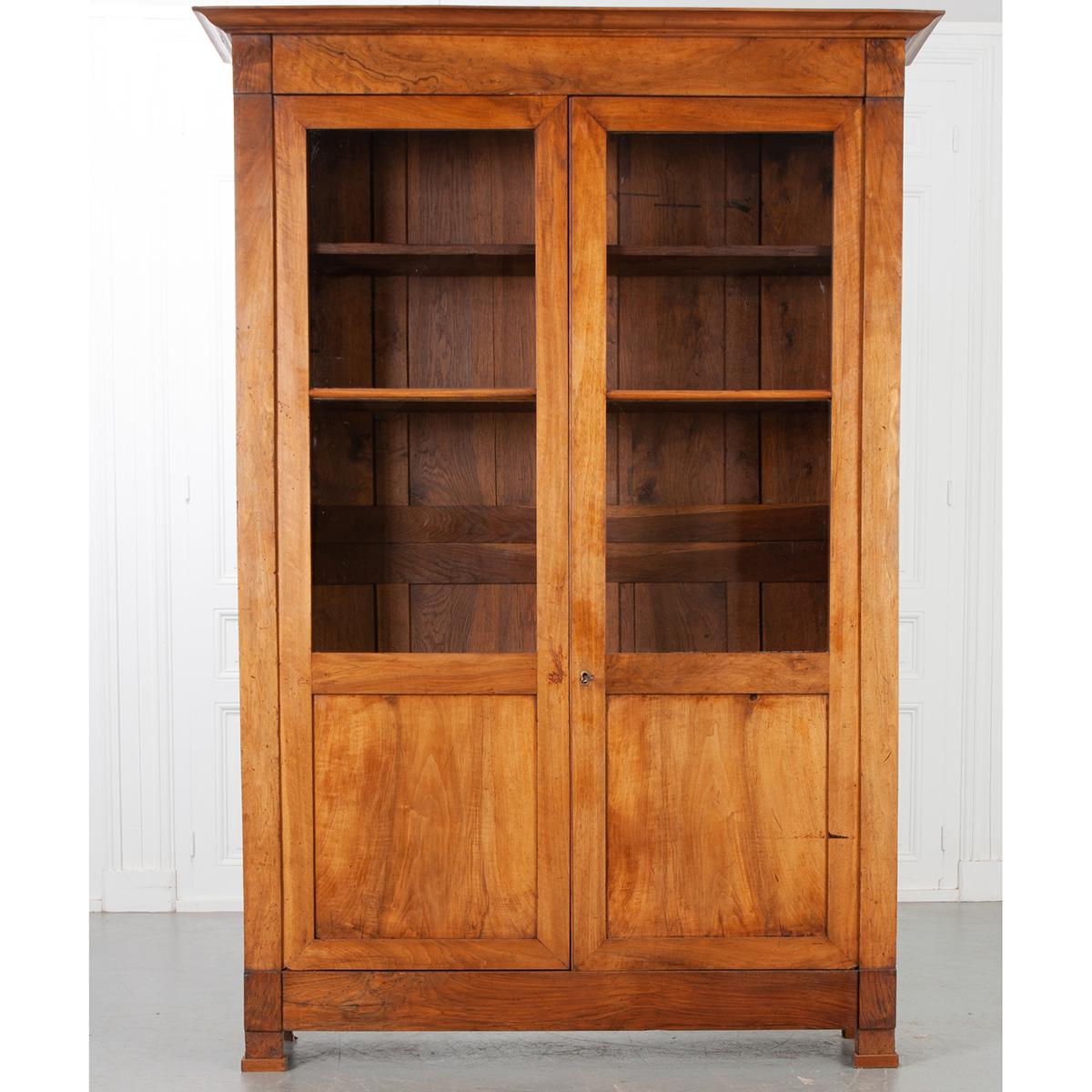 Great size! This is a French 19th century Louis Philippe mahogany bibliotheque. The grain of the mahogany wood is very interesting and has a wonderful patina. It has one key and a working lock. There are four adjustable shelves with a depth of 9-½”