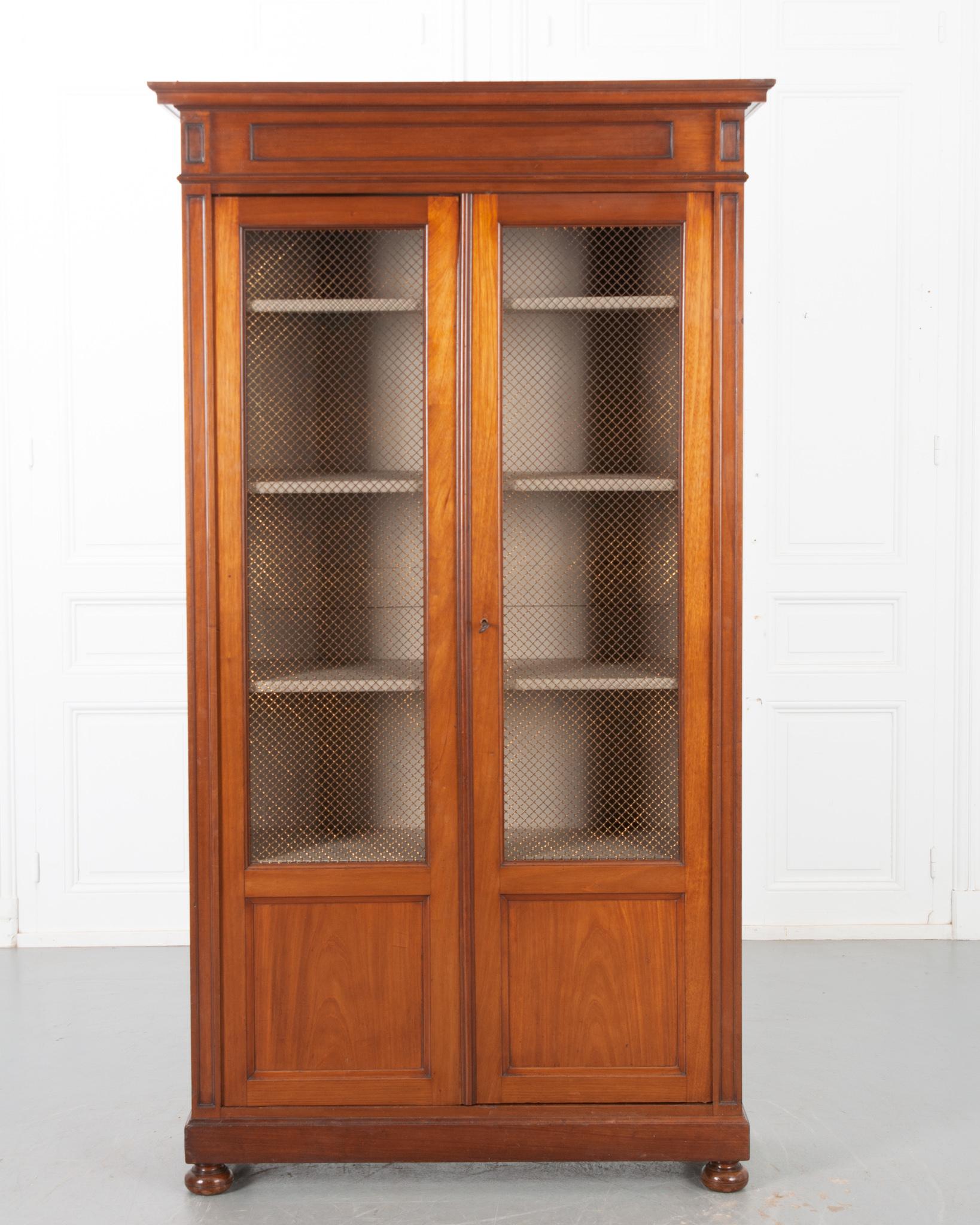 This handsome 19th century bibliotheque is the perfect combination of modern and antique! Designed with simplicity and function in mind, the cornice and paneling has minimal thumbnail carving. The richly patinated mahogany body compliments the worn