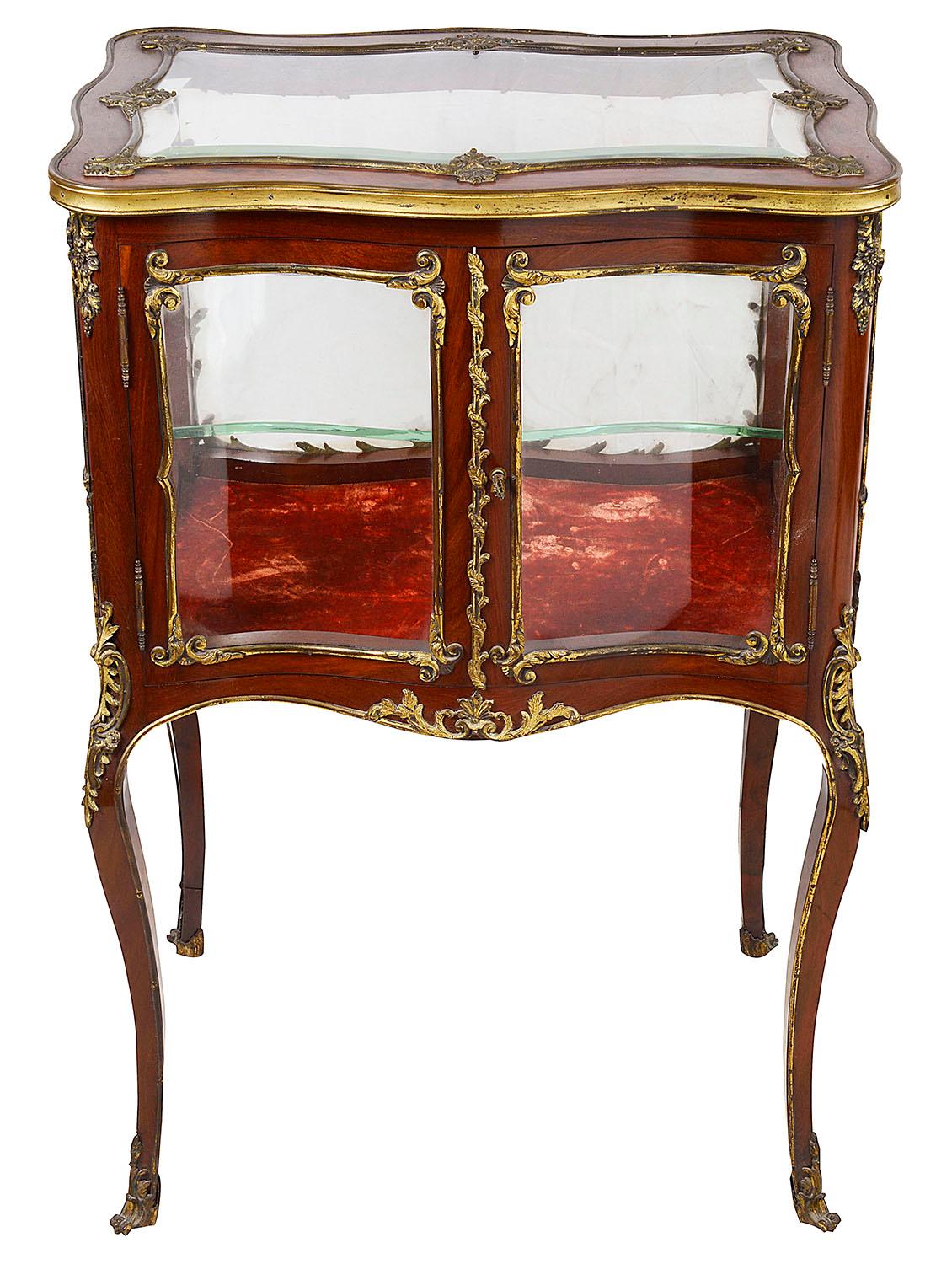 A good quality late 19th century French mahogany free standing bijouterie cabinet. having scrolling rococo, Louis XVI style gilded ormolu mounts, a single door opening to access the glass shelf within. Raised on elegant cabriole legs and terminating