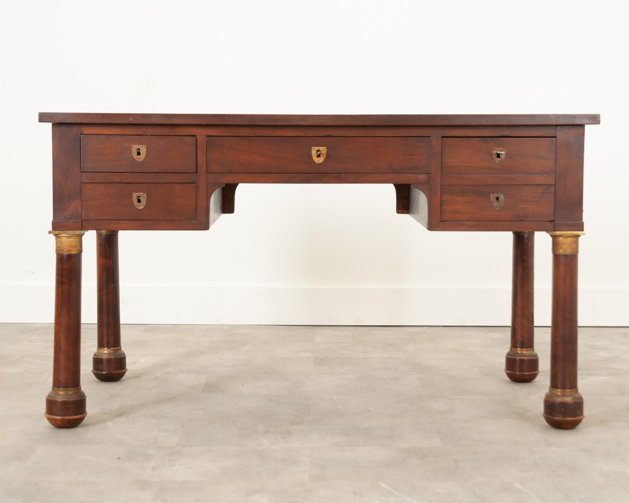 A handsome Empire style desk from 19th century France. Made from a beautiful mahogany that’s been cleaned and polished to reveal a warm patina. The top is inset with the original black leather, detailed with ornate gold tooling around the perimeter.