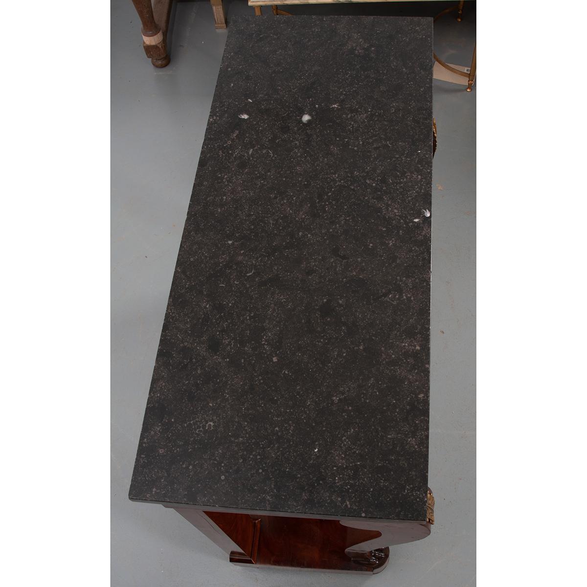 A beautiful marble top French Empire mahogany console. The black marble top is in wonderful antique condition. This console is very handsome, with two curved and scrolled front legs that support the apron and marble top. The apron houses a single