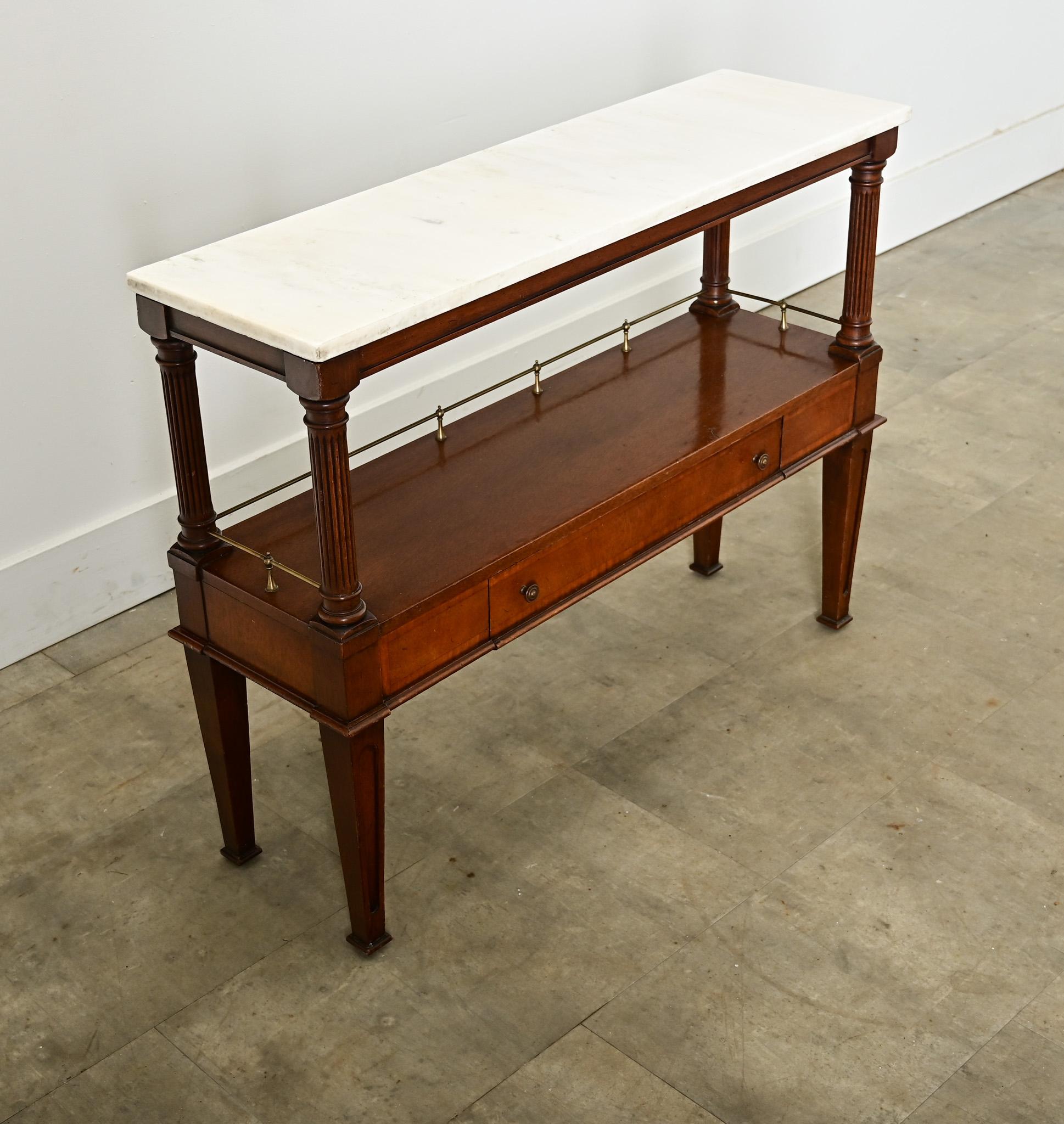 French 19th century diminutive mahogany and marble console-occasional table, in low and narrow proportions to use practically anywhere. This Directoire style piece is topped with white marble of ethereal vein patterns, rising on fluted, columnar