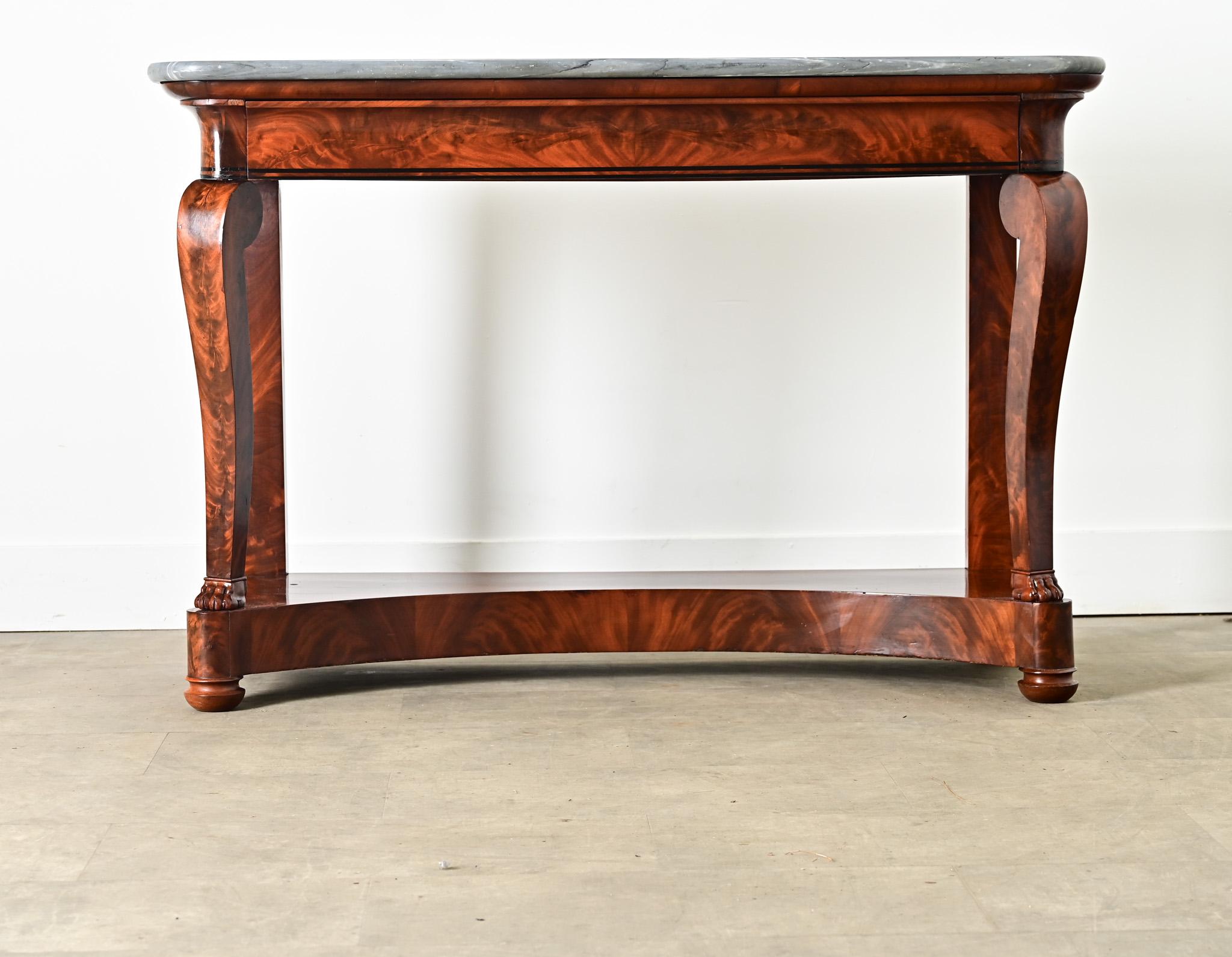 Un'imponente consolle in mogano francese del XIX secolo realizzata in stile Restauration (francese) con un piano in marmo grigio, un cassetto e un ripiano inferiore per riporre ed esporre oggetti. Il marmo presenta dense striature in una gamma di