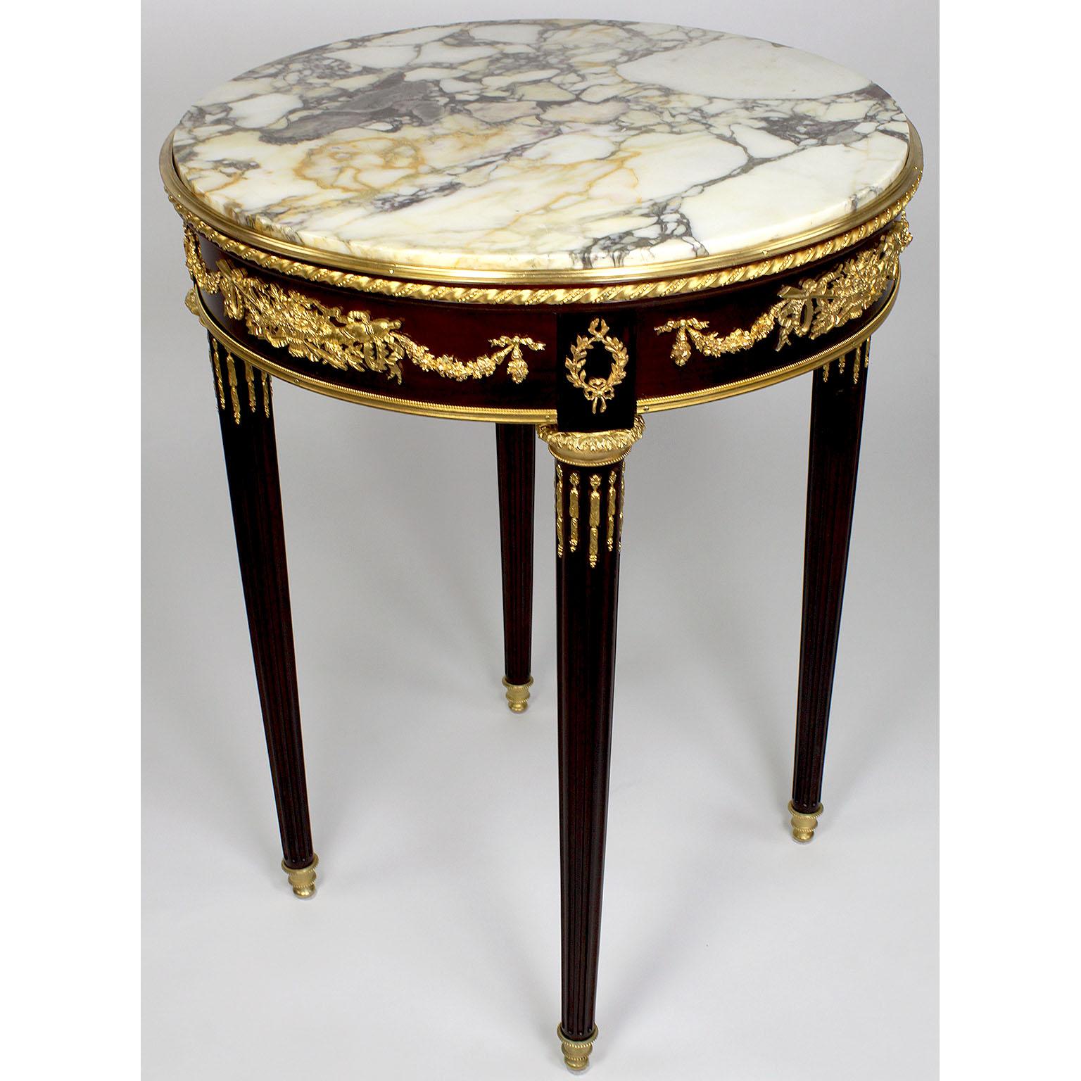 A very fine French 19th-20th century Louis XVI style mahogany and gilt bronze (Ormolu) mounted guéridon side table with marble top, attributed to François Linke, (1855-1946). The single drawer table with an inset round Brêche marble top surmounted