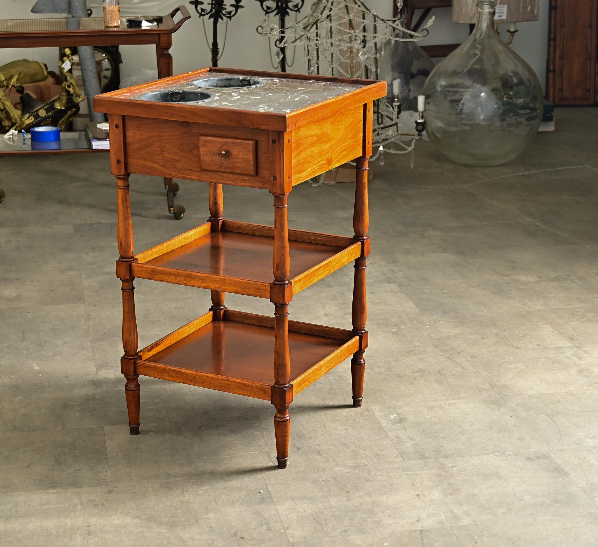A French mahogany and gray marble rafraîchissoir table from the late 19th century. Functioning like a bar cart or dry bar, this occasional table is adapted to keeping beverages cold by placing them in removable, galvanized ice buckets set flush