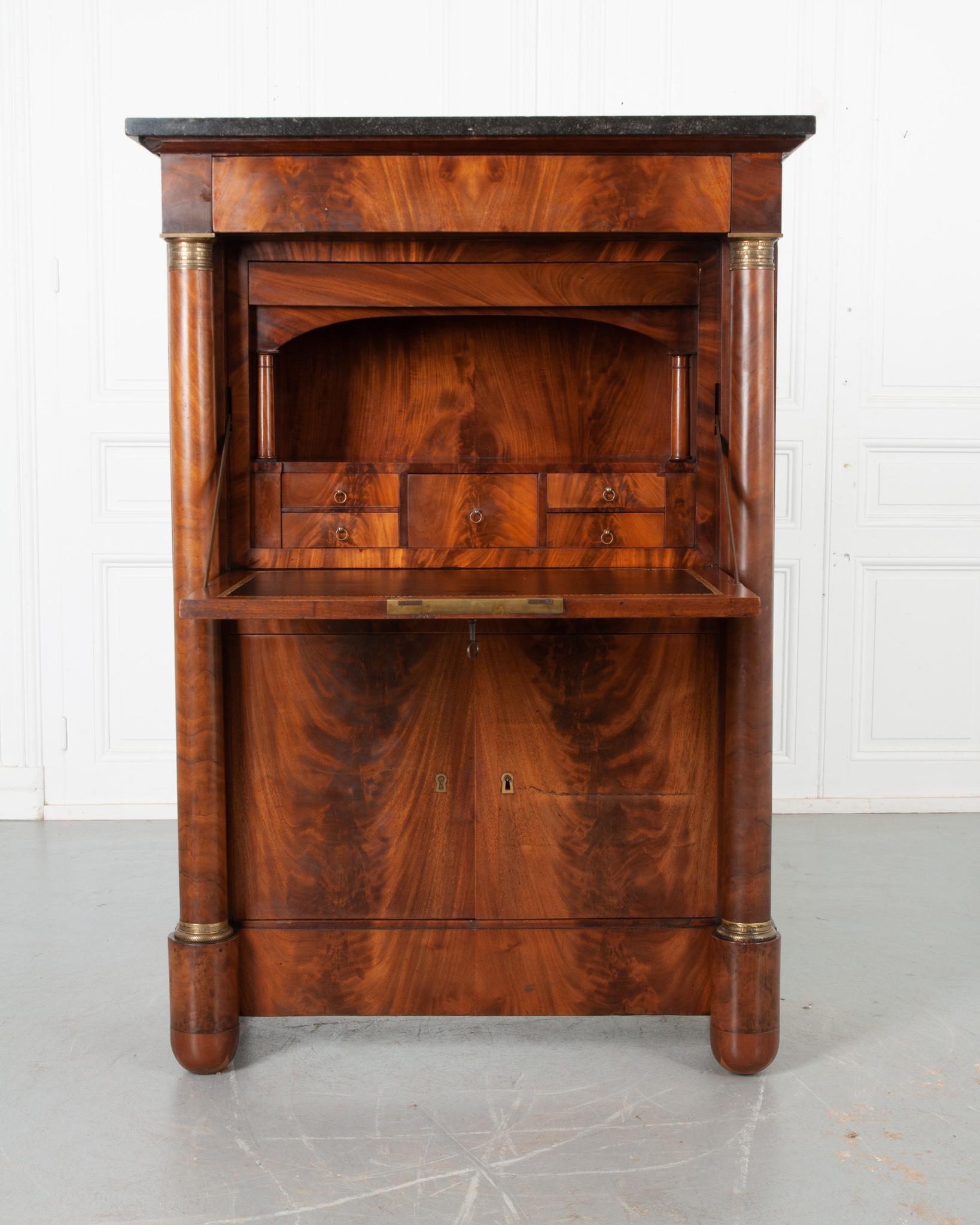 A dignified 19th century mahogany secre´taire a` abattant from France . This desk has an exceptional black, Belgian Granite top with fossil inclusions resting above a single drawer disguised into the apron. Just below the top drawer, the front of
