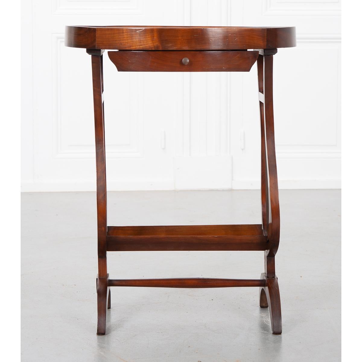 This is a delightful, mahogany accent table from France. The oval table top has a beveled frame extending above the top’s surface, giving the top a tray-like appeal, making it ideal for emptying your pockets. A single drawer just below the top, has