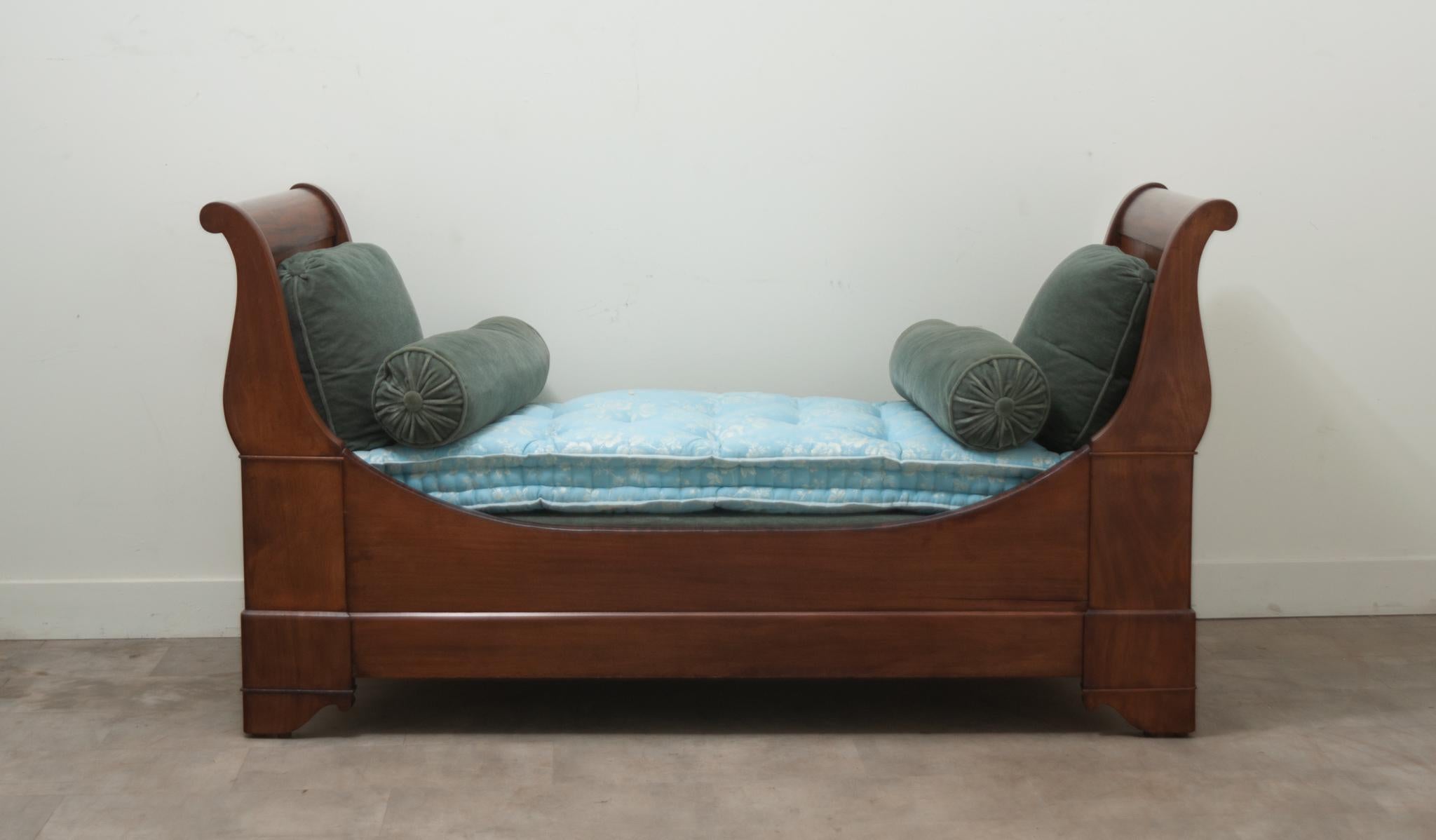This classic French sleigh bed is the perfect daybed for additional seating or sleeping. The mahogany bed frame comes with a custom fitted box spring, mattress, and set of four pillows. The bed rails attach to the headboard and footboard with steel