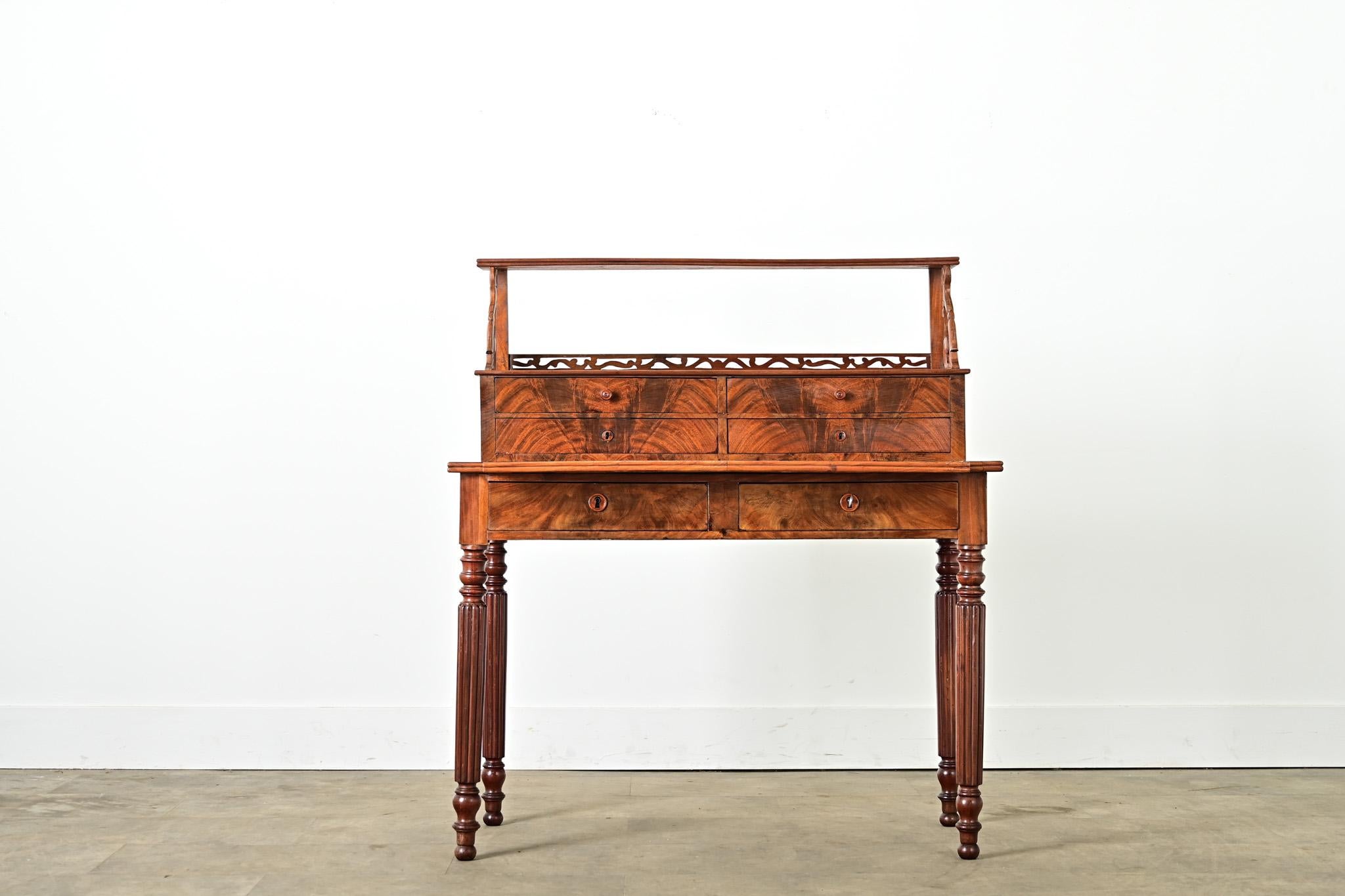 A petite mahogany and leather-top writing desk from France, circa 1840, ready to inspire you daily with its many unique features both decorative and functional. The writing surface is covered in beautiful almond-toned, tooled leather (with subtle
