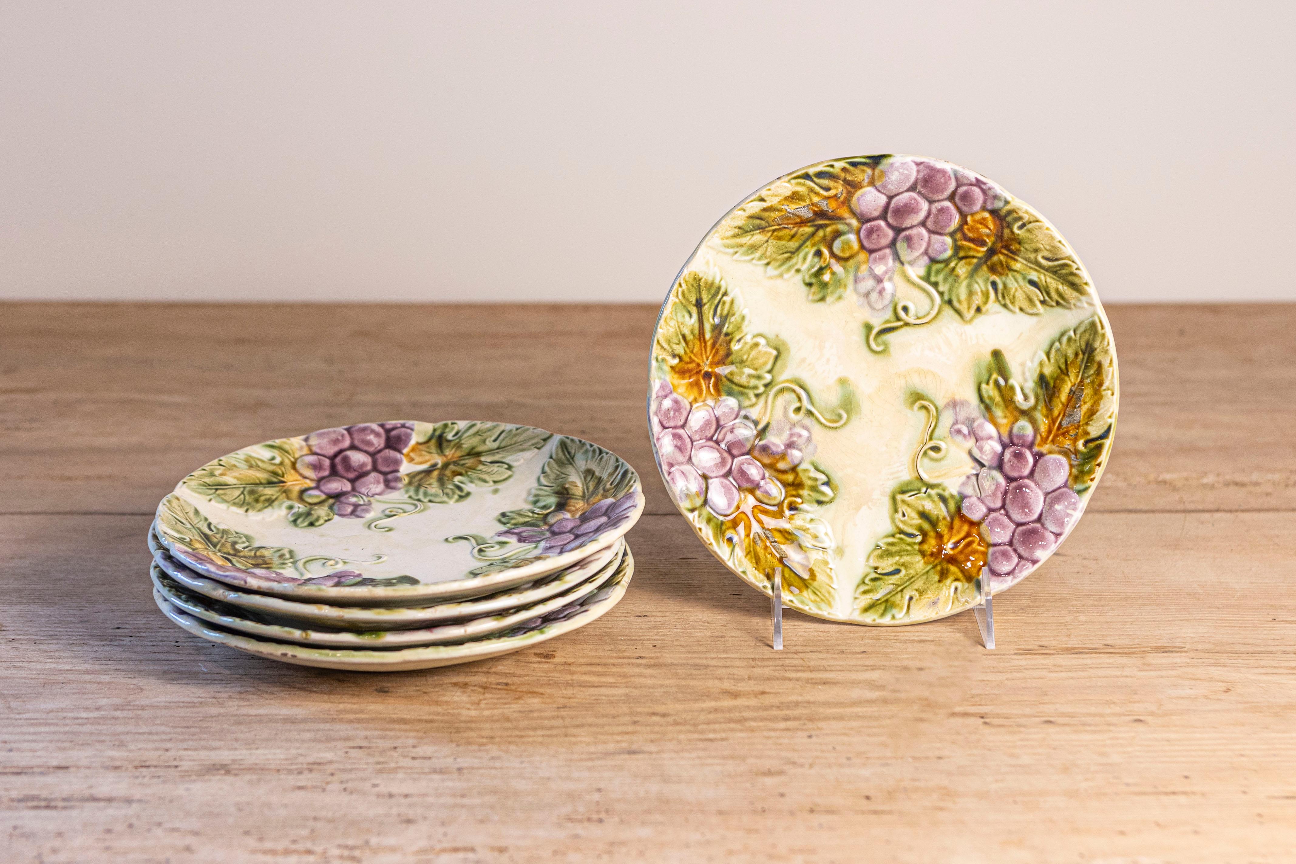 Assiettes à manger en majolique française du XIXe siècle, avec des raisins violets et leurs feuilles. Nous avons actuellement huit assiettes disponibles, vendues individuellement. Née en France au XIXe siècle, chacune de ces jolies assiettes est