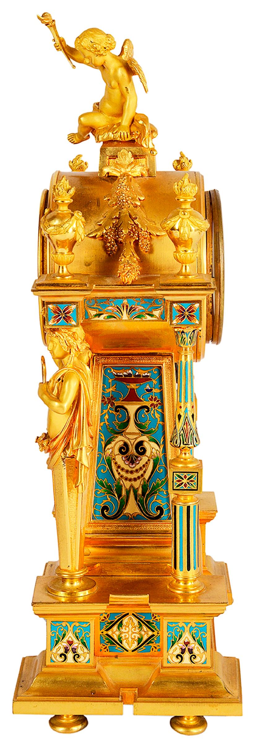 A very good quality French late 19th century gilded ormolu and champleve enamel mantel (fireplace) clock. Having urns and a cherub above the eight day clock that chimes on the hour and half hour. Supported by monopodia figures to either side of the