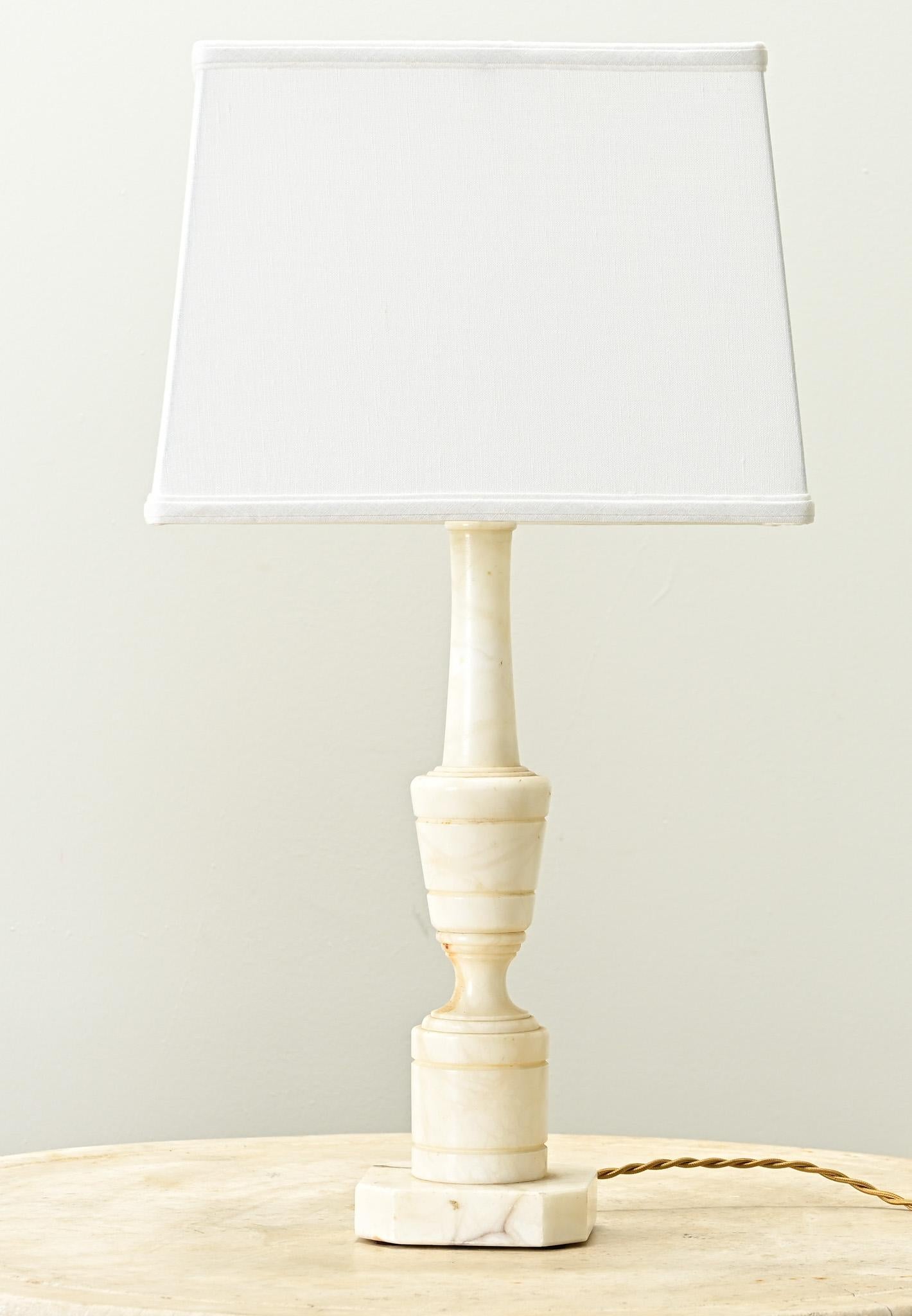A carved solid white marble table top lamp from France. Simple in design, this patinated lamp has a lot of character. Recently wired for US electrical using UL listed parts with a new rectangular linen shade. Be sure to look at the detailed images