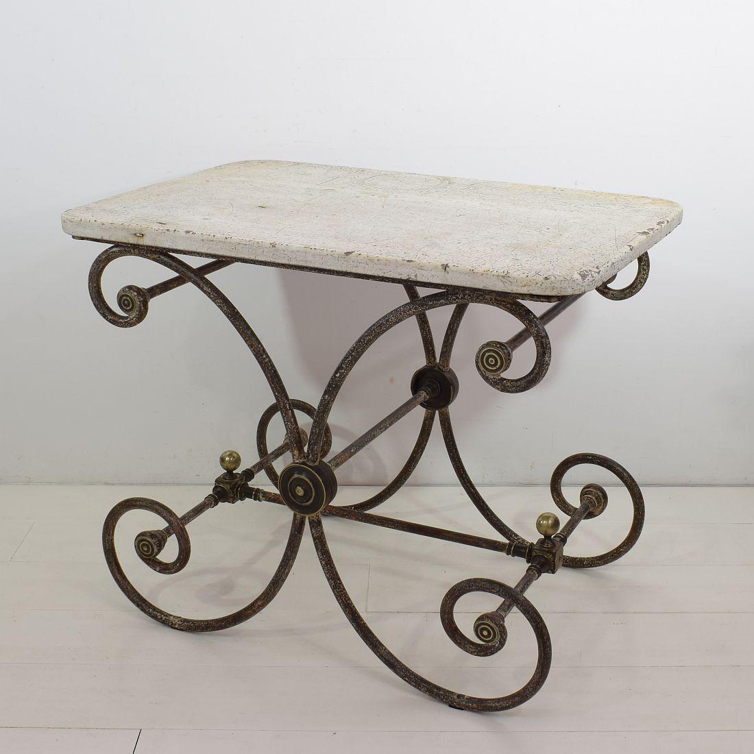 A wonderful 19th century French butcher/ pastry table from the South of France. Handsomely constructed with a cast iron base with its original and beautiful weathered marble top. Great brass ornaments. Small hairline visible in the marble top with