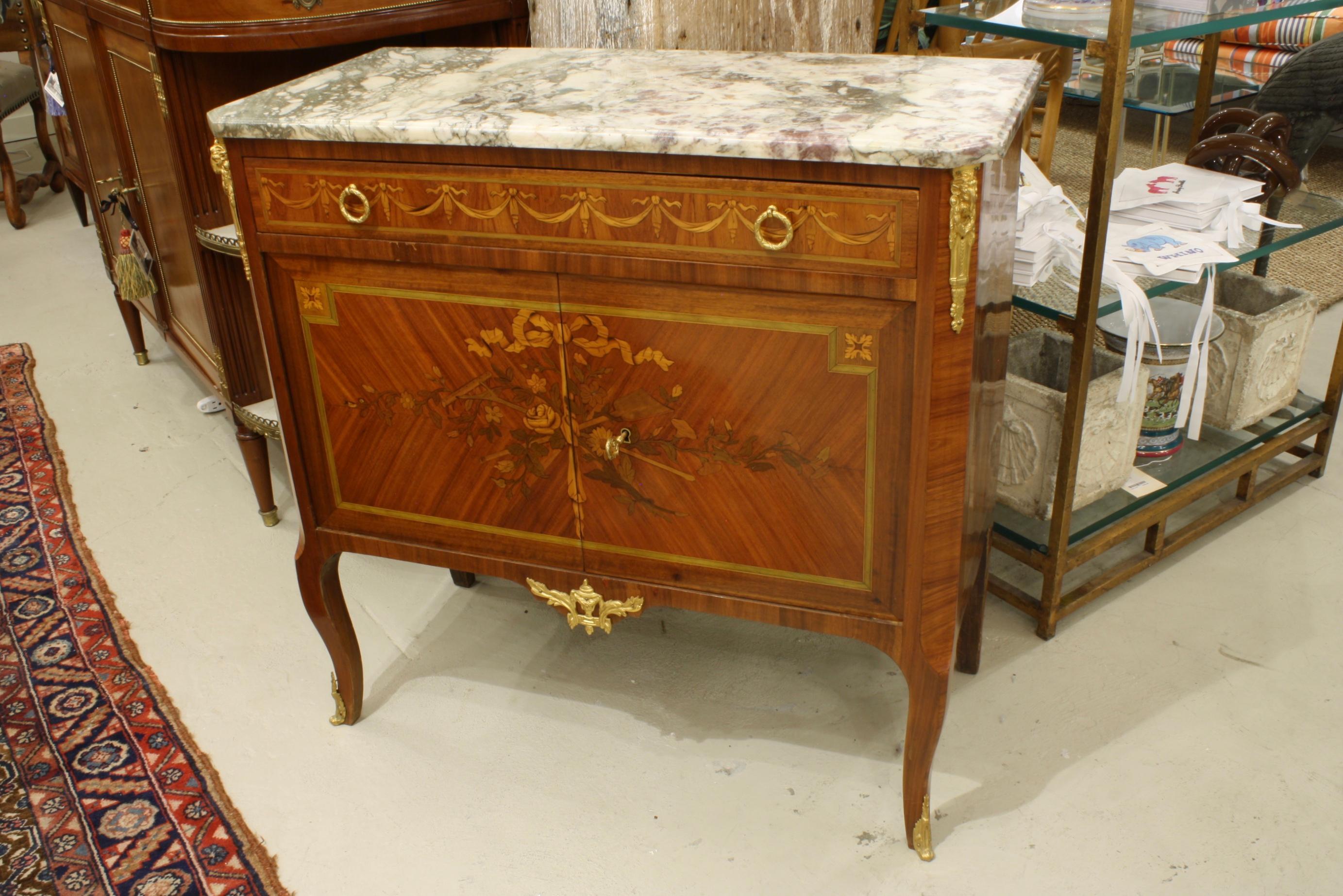 French Louis XV / Louis XVI Transitional style commode with breche violet marble top (Napoleon III period, circa 1870). This commode features floral marquetry with garden tools (rake and shovel) and rose garlands on the cabinet doors, and
